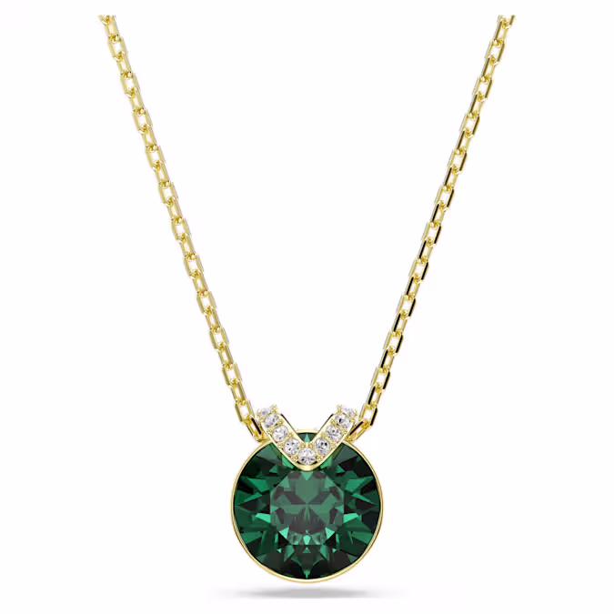 Deze fascinerende V-vormige hanger trekt alle ogen dankzij het centrale groene kristal in een zetting met een goudkleurige toplaag. Een sprankelende pavé voegt een extra laag schoonheid toe, terwijl de delicate ketting pure elegantie uitstraalt. Draag het samen met de bijpassende oorbellen voor een prachtige combinatie.