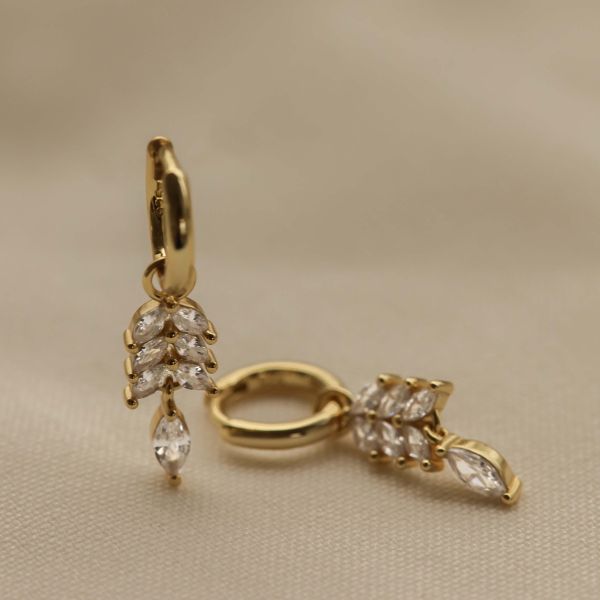 De Karma Hinged Hoops CLEO Feather Goldplated, modelnummer KAR-A169GP, zijn prachtige creool oorbellen die nikkelvrij zijn, ideaal voor gevoelige oren. Draag ze casual met een spijkerbroek en blouse, of elegant met een avondjurk. Ze voegen een stijlvolle touch toe aan elke outfit en benadrukken je persoonlijke stijl. Perfect voor dagelijks gebruik of speciale gelegenheden.