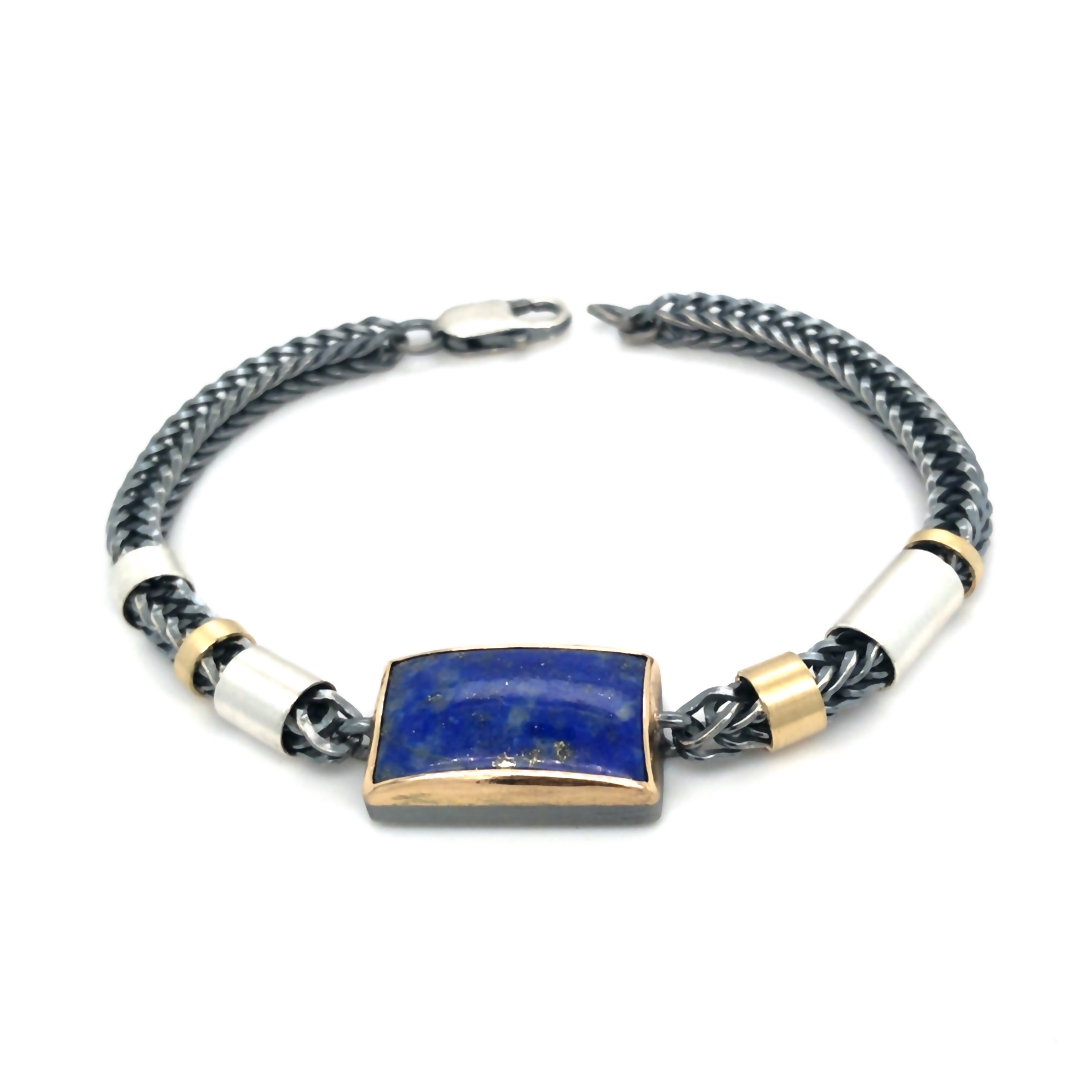 Das Armband in geschwärztem Silber und Gold 750 mit einem Lapislazuli ist ein einzigartiges Schmuckstück. Ideal für elegante Anlässe oder als Highlight im Alltagslook. Tragen Sie es solo oder in Kombination mit anderen Armbändern für einen stilvollen Auftritt. Perfekt für jeden Schmuckliebhaber. Länge 21 cm UNIKAT