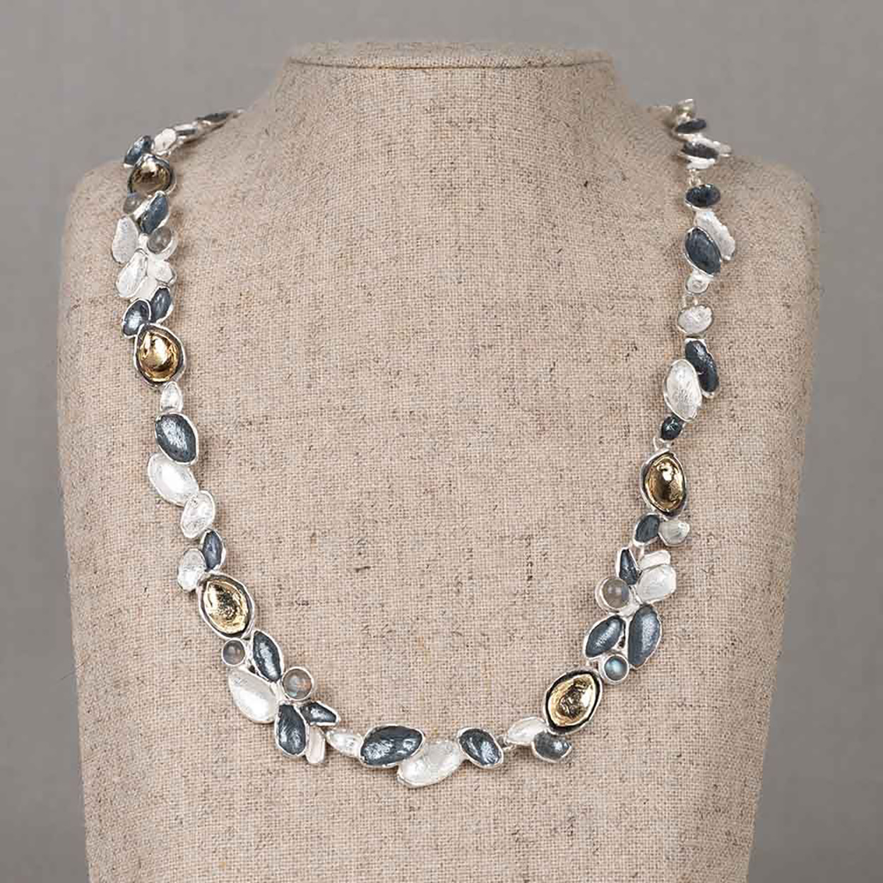 Collier gemaakt van blaadjes van 925 sterling zilver, geoxideerd zilver en zilver verguld met tussen de blaadjes Labradoriet.
