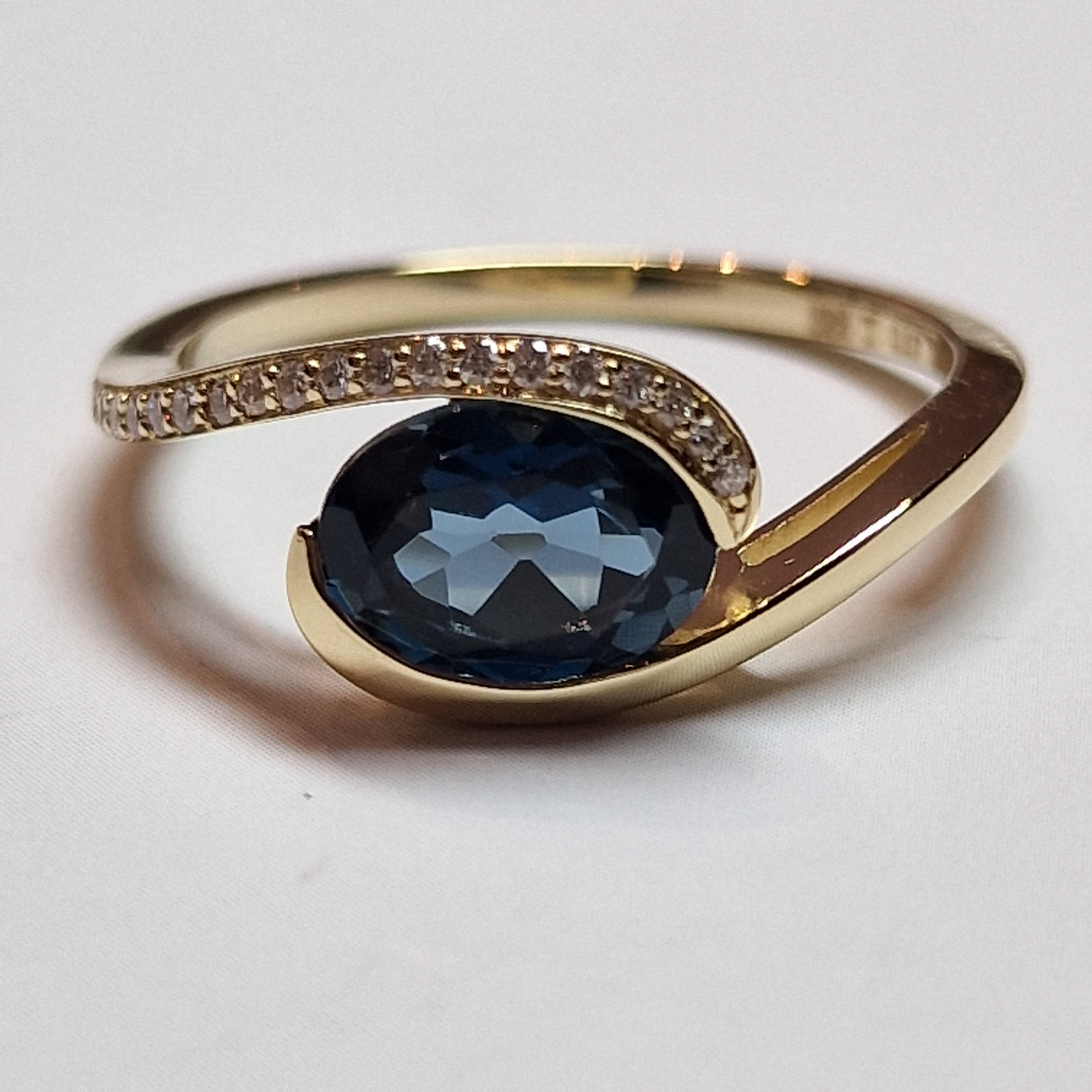 14k geelgouden slagring met een ovale London Blue Topaas en diamant