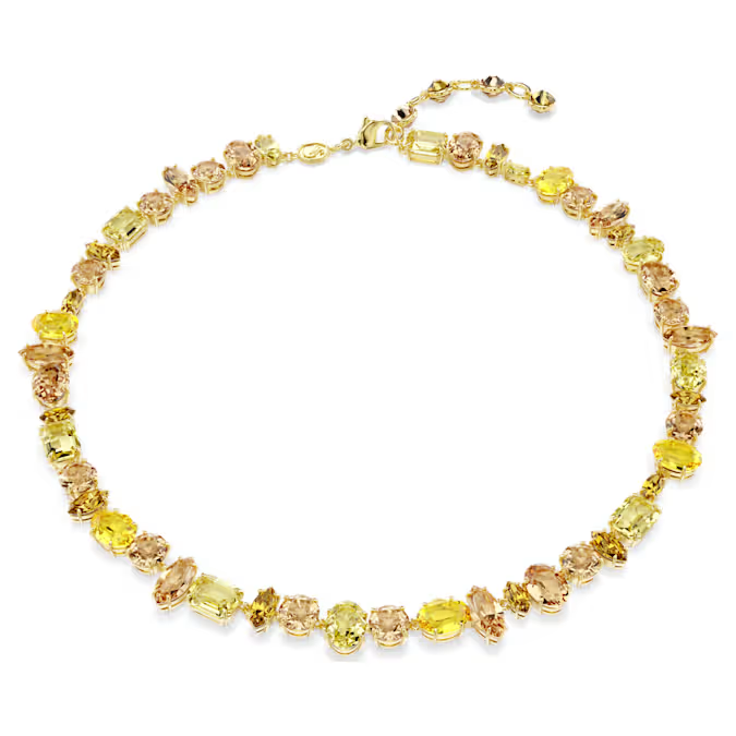 Verhoog de intensiteit met deze schitterende ketting met goudkleurige toplaag. Het all-around ontwerp, ideaal voor dagelijks gebruik of speciale gelegenheden, is versierd met kristallen in klauwzetting in een dramatische mix van slijpvormen en gele en amberkleurige tinten. Deze ketting is symbolisch voor de onverwachte vormen en levendige schoonheid van Gema en straalt nog helderder wanneer hij wordt gedragen met bijpassende sieraden uit dezelfde lijn.