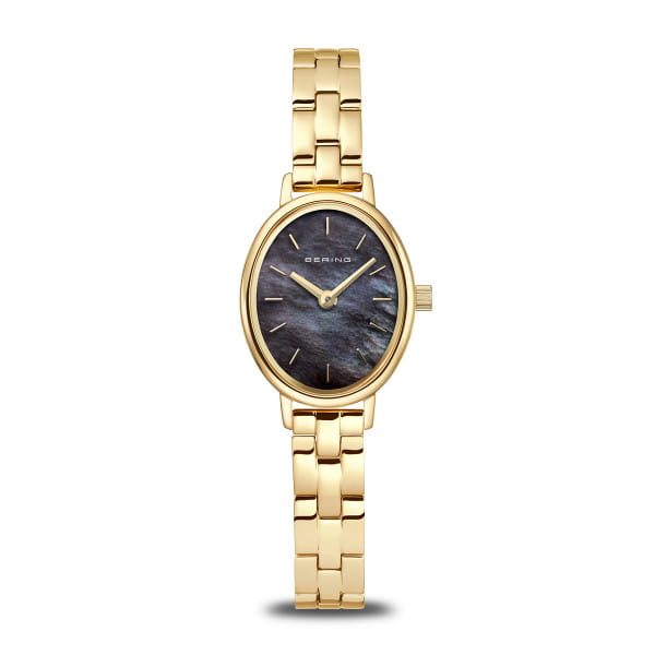  Magisch wie Polarlicht über arktischem Himmel – diese BERING Damenuhr aus der Classic-Kollektion ist ein leuchtendes Statement für Individualität und feminine Eleganz. 
 Im Zentrum steht das faszinierende Zifferblatt aus echtem schwarzem Perlmutt, das je nach Lichteinfall irisierende Farbspiele offenbart. Umrahmt wird dieses Naturwunder von einem ovalen Gehäuse in glänzendem Goldton, das die zarten goldfarbenen Zeiger und Indizes stilvoll ergänzt. Jedes Zifferblatt ist ein Unikat. 
 Das fein polierte Gliederarmband mit Titanelementen vereint den edlen Look von Edelstahl mit dem Tragekomfort von Titan: leicht, hautfreundlich und angenehm kühl auf der Haut. Das kratzfeste Saphirglas schützt die zarte Schönheit dauerhaft vor äußeren Einflüssen, während ein präzises Quarzwerk im Inneren für zuverlässige Zeit sorgt. Mit nur 6 mm Gehäusehöhe und 20 mm Breite wirkt die Uhr besonders filigran und schmeichelt dem Handgelenk mit dezentem Luxus. 
 Die Uhr misst 24 mm in der Länge, besitzt eine Faltschließe für sicheren Halt, das Armband ist 180 mm lang und 8 mm breit. Sie ist bis zu 3 ATM wasserdicht. 