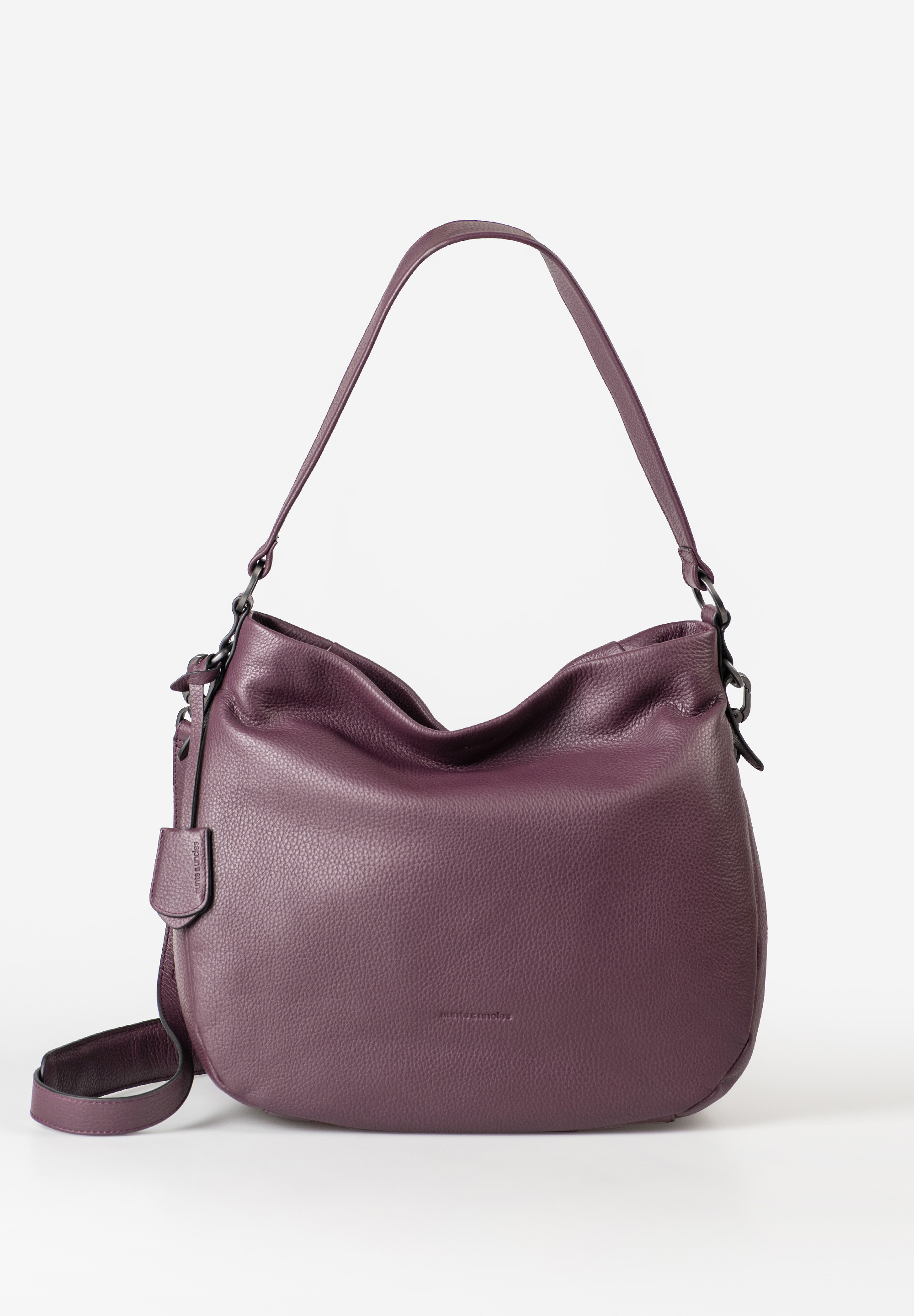 Darling – Jouw Nieuwe Beste Vriendin
Maak kennis met Darling – de stijlvolle schoudertas die elegantie en praktisch gemak moeiteloos combineert. Gemaakt van boterzacht, generfd nappa-leer en ontworpen in een klassieke vorm, voelt Darling net zo fijn aan als ze eruitziet. Of je nu naar kantoor gaat, een dagje uit plant of gewoon goed georganiseerd op pad wilt – Darling is er voor jou.

Het ruime hoofdvak biedt voldoende plaats voor documenten of tijdschriften in A4-formaat en is slim ingedeeld met diverse vakken, een sleutelriempje, pennenhaken en een uitneembaar etui voor kleine spullen. Naast de brede schouderband heeft Darling ook een afneembare en verstelbare crossbodyriem met sportieve karabijnhaken. En als extra detail: een stijlvol leren adreslabel.

Waarom Darling altijd met je mee wil:

Ruim hoofdvak met ritssluiting

Achtervak met rits en extra drukknoop voor extra veiligheid

Binnenvak met rits, steekvak, kaartsleuf en pennenhaken

Sleutelriempje & uitneembaar etui met ritssluiting

Brede schouderband & verstelbare, afneembare crossbodyriem

Leren adreslabel inbegrepen

Geschikt voor documenten/tijdschriften in A4-formaat

Inclusief lichtgekleurde voering en stofzak

Kleur: Merlot
Formaat: ca. 33 × 10,5 × 30 cm | Inhoud: ca. 10 L
Materiaal: Zacht nappa-leer (LWG-gecertificeerd)

Met zorg vervaardigd.
Darling is handgemaakt van milieubewust geproduceerd leer van LWG-gecertificeerde looierijen – voor een duurzame tas met karakter.