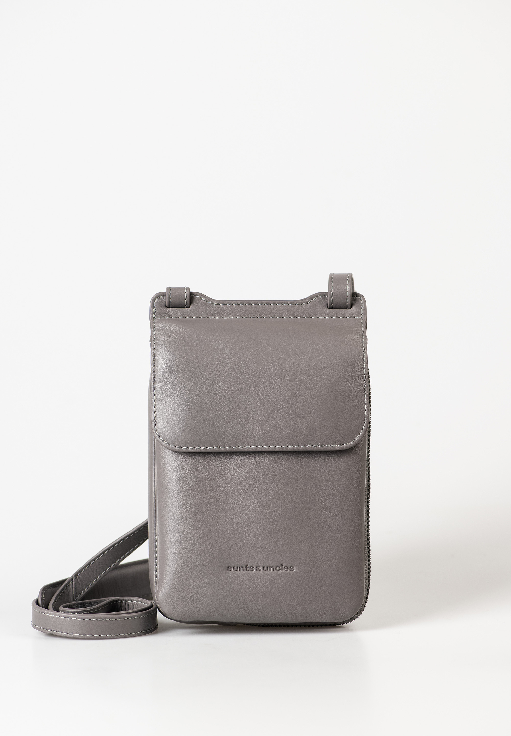 aunts & uncles – TULIP Micro Bag (eiffel tower)
De Tulip uit de Jamie’s Orchard collectie van aunts & uncles is dé perfecte mix van een smartphone tas en portemonnee in één stijlvol ontwerp. Klein van formaat, groots in functionaliteit – ideaal voor iedereen die onderweg licht en georganiseerd wil reizen.

Wat maakt de Tulip zo bijzonder?
✔ Alles-in-één design: De Tulip is compact, maar verrassend ruim. In de twee steekvakken aan de voorzijde past moeiteloos een smartphone tot 6,7 inch. Het achtervak met rondom lopende rits fungeert als volwaardige portemonnee.
✔ Slim ingedeeld: Drie kaartsleuven, een ritsvak voor muntgeld en genoeg ruimte voor pasjes en andere kleine essentials.
✔ Comfortabel & verstelbaar: De smalle schouderband is in lengte verstelbaar en voorzien van een extra schouderpad voor meer draagcomfort.
✔ Hoogwaardige materialen: Gemaakt van soepel, plantaardig gelooid en met de hand gewaxt rundsleer met een uniek karakter.
✔ Verfijnde afwerking: De binnenkant is afgewerkt met een mooi bedrukt textiel – stijl tot in de details.

Productspecificaties
Kleur: eiffel tower (taupe/bruingrijs)

Inhoud: ca. 0,5 liter

Afmetingen: ca. 13 x 4 x 18 cm

Geschikt voor: smartphones tot 6,7 inch

Draagriem: verstelbaar, met schouderpad

Materiaal: met de hand gewaxt rundsleer

Voering: bedrukt katoen

Collectie: Jamie’s Orchard

Onderhoud
Het hoogwaardige leer vraagt om zorg. Gebruik een geschikt lederverzorgingsproduct om de Tulip soepel en mooi te houden. Zo blijft jouw tas jarenlang een stijlvolle metgezel.