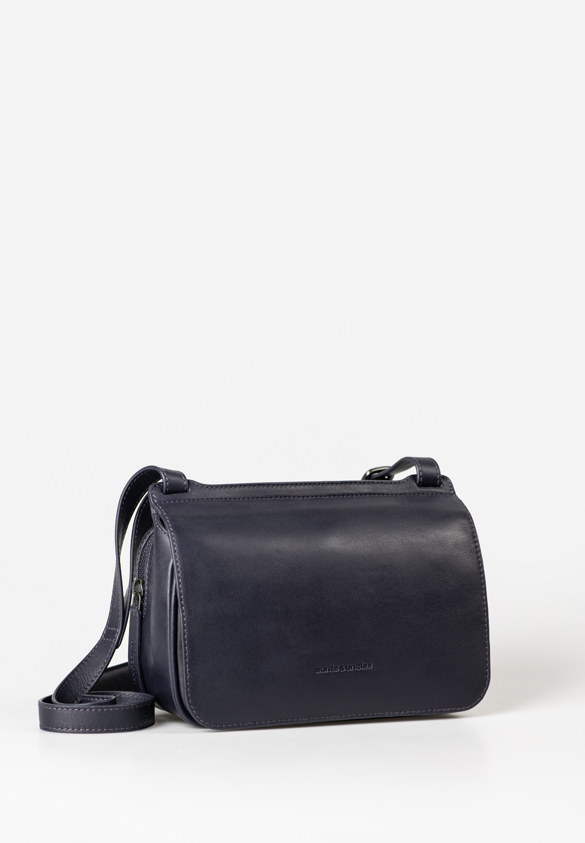 aunts & uncles – MAGNOLIA cameratas (dark horizon)
De Magnolia uit de Jamie’s Orchard collectie van aunts & uncles is een compacte en stijlvolle cameratas met een moderne boxy vorm. Achter het minimalistische design schuilt een slimme organisatie, waardoor je al je essentials overzichtelijk en veilig kunt meenemen – ideaal voor dagelijks gebruik of een dagje uit.

Waarom Magnolia jouw nieuwe favoriete tas wordt
✔ Slim & overzichtelijk: Het ruime hoofdvak met rits biedt plek voor je smartphone, sleutels, portemonnee en meer. Binnenin vind je een ritsvak, steekvak en geïntegreerde kaarthouder met drie sleuven.
✔ Extra opbergruimte: Onder de magnetische overslag zit een grote voorvak verborgen. Achteraan zit een ritsvak met drukknoopsluiting voor extra veiligheid.
✔ Comfortabel draaggemak: Dankzij de verstelbare schouderband met schouderpad draag je Magnolia de hele dag comfortabel.
✔ Moderne look: De strakke, kastenachtige vorm geeft deze tas een modieuze en eigentijdse uitstraling – perfect te combineren met zowel casual als chique outfits.
✔ Praktische details: Inclusief sleutelkoord zodat je nooit meer naar je sleutels hoeft te zoeken.

Productspecificaties
Kleur: dark horizon (diepblauw/grijsachtig)

Inhoud: ca. 3,5 liter

Afmetingen: ca. 23,5 x 10 x 15,5 cm

Materiaal: hoogwaardig, met de hand afgewerkt leer (plantaardig gelooid)

Voering: bedrukt katoen

Draagriem: verstelbaar met schouderkussen

Collectie: Jamie’s Orchard

Indeling: hoofdvak met rits, voorvak onder overslag, achtervak met rits & drukknop, sleutelkoord, kaarthouder, binnenvakken

Onderhoud
Voor langdurige bescherming en behoud van het leer raden we aan om de tas regelmatig te behandelen met een speciaal lederverzorgingsproduct. Zo blijft Magnolia jarenlang in topvorm.