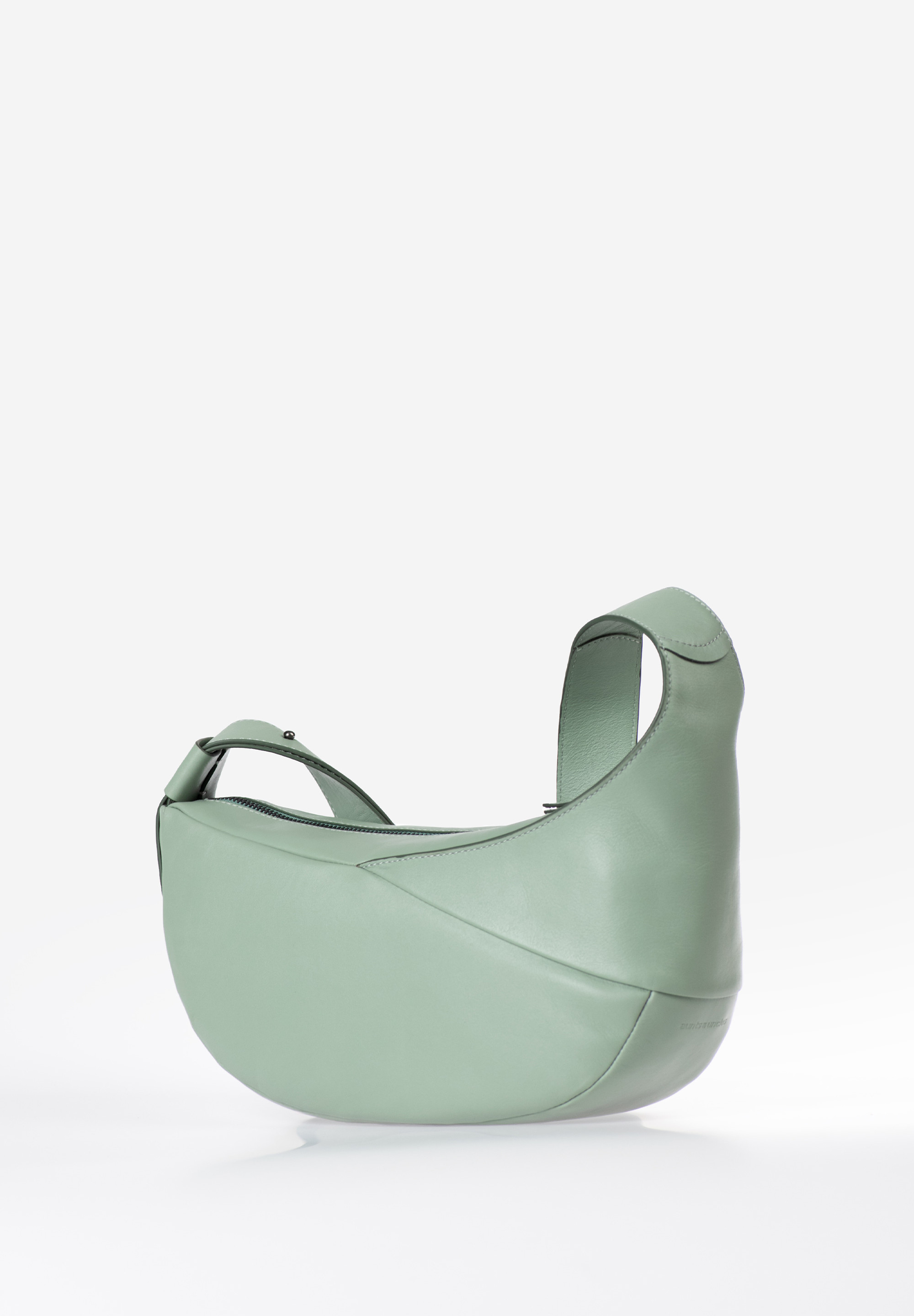 aunts & uncles – BEE BALM Halfmoon Bag (sage green)
De Bee Balm uit de Jamie’s Orchard collectie van aunts & uncles is een stijlvolle Halfmoon Bag in een praktische, middelgrote uitvoering. Deze tas combineert een strak, tijdloos design met subtiele details zoals een siernaad en een zachte, afgeronde vorm. Perfect voor ontspannen dagen in de stad, een bioscoopbezoek of een koffie-date.

Waarom kiezen voor Bee Balm?
✔ Tijdloos & praktisch: Met haar moderne halve maanvorm past Bee Balm moeiteloos bij elke casual outfit, van marktbezoek tot museumdag.
✔ Slim ingedeeld: Het hoofdvak met rits biedt ruimte voor je essentials, waaronder een smartphonevak, een binnenvak met rits en een sleutelkoord.
✔ Comfortabele pasvorm: Dankzij de brede, verstelbare schouderband draag je de tas comfortabel over de schouder of crossbody.
✔ Kwaliteitsleer: Vervaardigd van met de hand gewaxt, plantaardig gelooid rundsleer dat zich soepel vormt naar je lichaam en prachtig veroudert.
✔ Afwerking tot in detail: Voorzien van een lichte katoenen voering en geleverd met een handige stofzak voor veilige opberging.

Productspecificaties
Kleur: sage green (zachtgroen)

Inhoud: ca. 6 liter

Afmetingen: ca. 32 x 13 x 15 cm

Schouderbandlengte: ca. 70 – 95 cm (verstelbaar)

Materiaal: soepel, plantaardig gelooid en met de hand gewaxt rundleer

Voering: lichtkleurig katoen

Indeling: hoofdvak met rits, binnenvak met rits, steekvak, sleutelkoord

Collectie: Jamie’s Orchard

Inclusief: stofzak voor opbergen

Onderhoud
Voor een langdurig mooie uitstraling en bescherming van het leer adviseren we regelmatig gebruik van een geschikt lederonderhoudsproduct. Zo blijft Bee Balm jarenlang jouw betrouwbare en stijlvolle metgezel.
