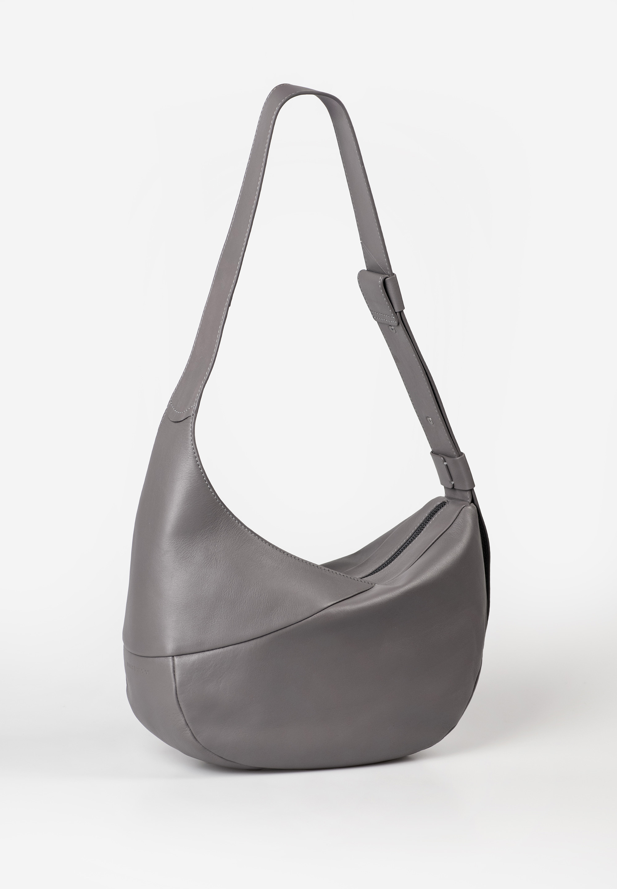 aunts & uncles – BLOSSOM Halfmoon Bag (eiffel tower)
De Blossom uit de Jamie’s Orchard collectie van aunts & uncles is de grootste variant binnen de iconische Halfmoon-familie. Gemaakt van hoogwaardig, zacht rundsleer en ontworpen met een oog voor detail, combineert Blossom moderne elegantie met praktische opbergruimte. De perfecte tas voor wie stijl en functionaliteit wil verenigen – op je werk, in de stad of onderweg.

Waarom Blossom jouw favoriet wordt
✔ Ruime inhoud: Met een volume van ca. 9 liter is Blossom ruimer dan haar zusjes Orchid en Bee Balm – perfect voor wie net iets meer wil meenemen.
✔ Slimme indeling: Het hoofdvak met rits bevat een ruim steekvak, een binnenvak met rits en een sleutelkoord voor overzicht en veiligheid.
✔ Flexibele draagwijze: Dankzij de brede, in lengte verstelbare band kun je Blossom comfortabel over de schouder, als crossbody of op de rug dragen.
✔ Iconisch design: De elegante halve maanvorm, gecombineerd met het soepele leer en de neutrale kleur, maakt deze tas tot een veelzijdige klassieker.
✔ Verfijnde afwerking: Lichtgekleurd katoenen binnenvoering en een stofzak voor veilige opberging zijn inbegrepen.

Productspecificaties
Kleur: eiffel tower (taupe/grijsbruin)

Inhoud: ca. 9 liter

Afmetingen: ca. 32 x 13 x 22 cm

Schouderbandlengte: ca. 70 – 95 cm

Materiaal: plantaardig gelooid, met de hand gewaxt premium-rundleer

Voering: licht katoen met print

Indeling: hoofdvak met rits, binnenvak met rits, steekvak, sleutelkoord

Collectie: Jamie’s Orchard

Inclusief: beschermende stofzak

Onderhoud
Om het leer soepel en mooi te houden, raden we aan om de tas regelmatig te behandelen met een verzorgingsproduct speciaal voor natuurleer.