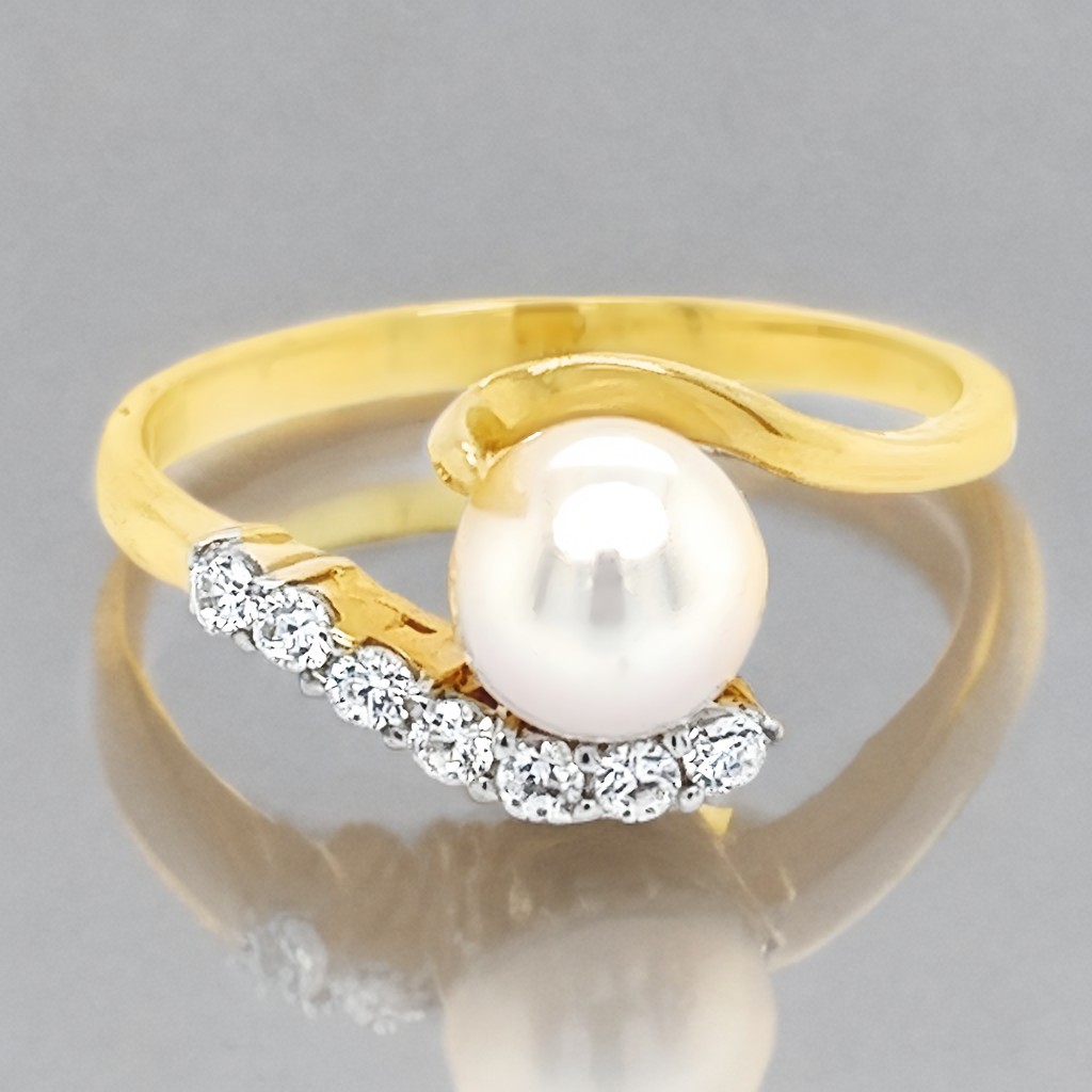 14k Geelgouden ring met een Zoetwater parel en zeven zirkonia steentjes.