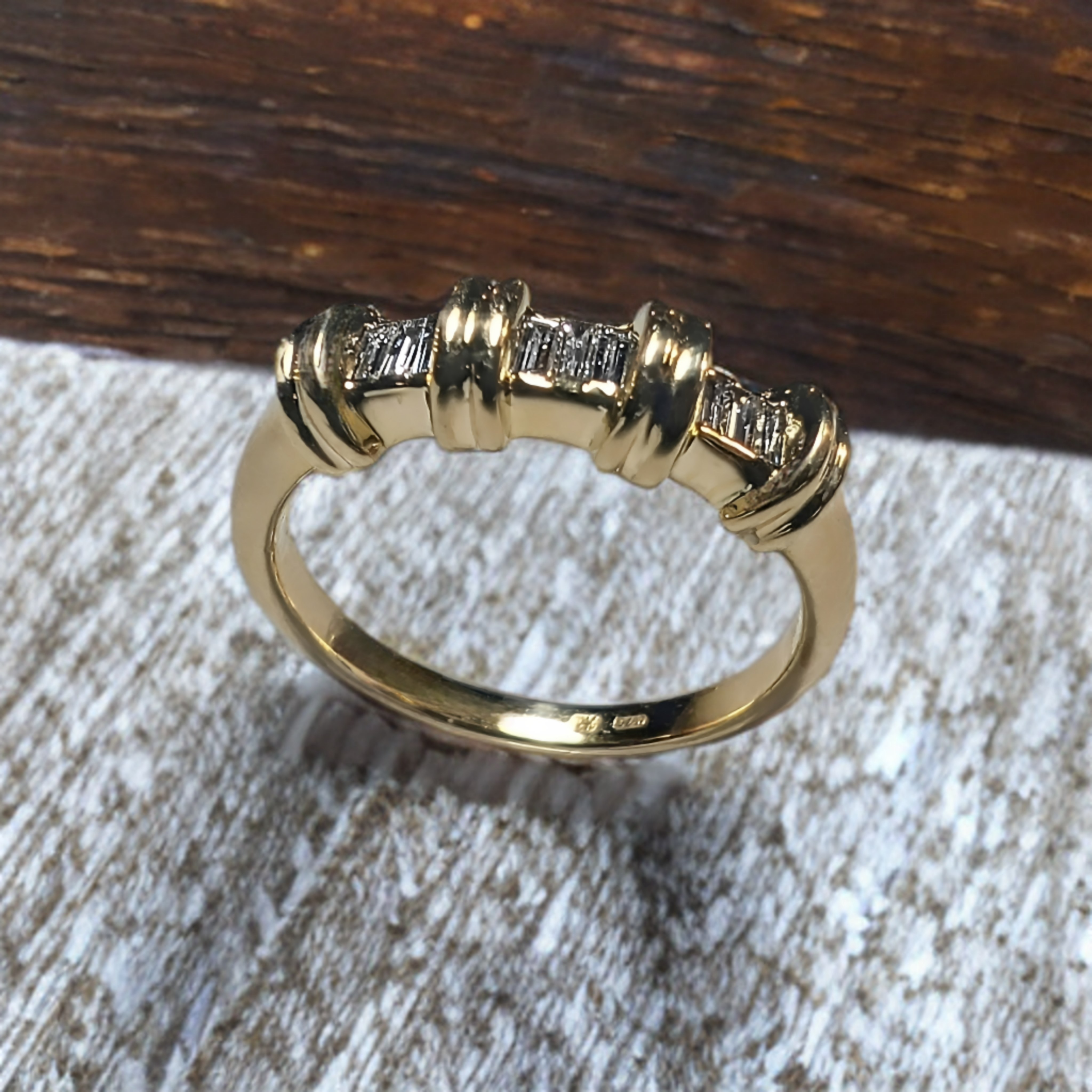 Een 18 karaats geel gouden ring gezet met 9x 0.02ct Baguette geslepen diamanten van natuurlijke oorsprong.