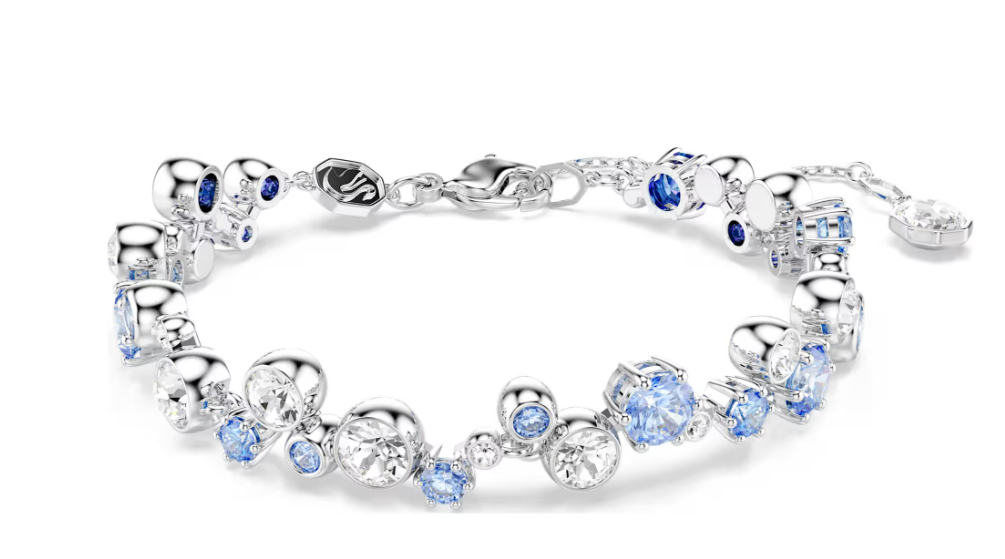 Wikkel uw pols in licht dankzij deze levendige Constella-armband. Het ontwerp met rhodium toplaag is volledig bezet met heldere kristallen en blauwe Swarovski Zirkonia in diverse formaten en tinten, elk in een klauw- of lunettezetting. Deze glanzende armband met karabijnsluiting geeft een verfijnde afwerking aan elke outfit en kan worden gedragen met de bijpassende ketting.