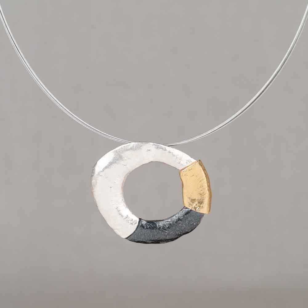 Hanger gemaakt van 925 sterling zilver, geoxideerd zilver en verguld incl collier. Draag deze organisch ronde hanger aan een mooie spang en combineer met een mooi paar oorbellen en een ring!