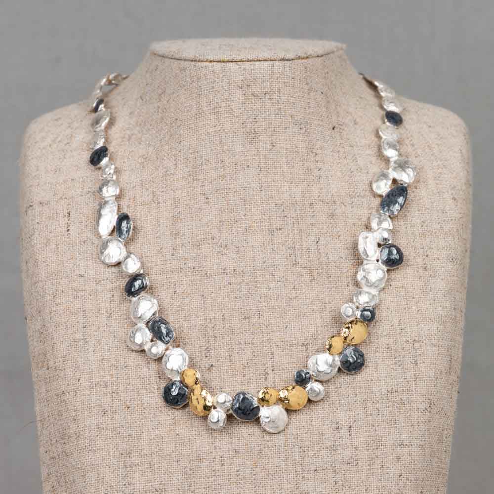 Uniek collier van 925 sterling zilver, geoxideerd en verguld. Dit speelse en elegante collier is vervaardigd uit 925 sterling zilver en prachtig afgewerkt met zowel geoxideerd zilver als verfijnd zilver verguld. De organische schakels hebben een fantasierijke vorm die doet denken aan een klein lieveheersbeestje. Subtiel, stijlvol en met een ambachtelijke look. Combineer met de bijpassende oorknopjes voor een complete look!