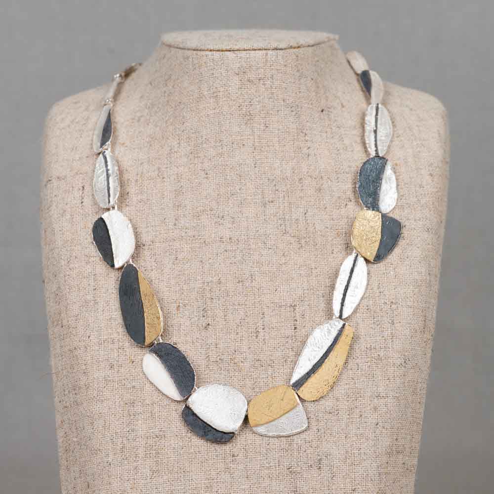 Collier gemaakt van 925 sterling zilver, geoxideerd zilver en verguld. Door het gebruik van deze materialen ontstaan de 3 kenmerkende kleuren die wij bij Jeh veel gebruiken. Combineer dit collier met de bijpassende oorbellen voor een complete look!