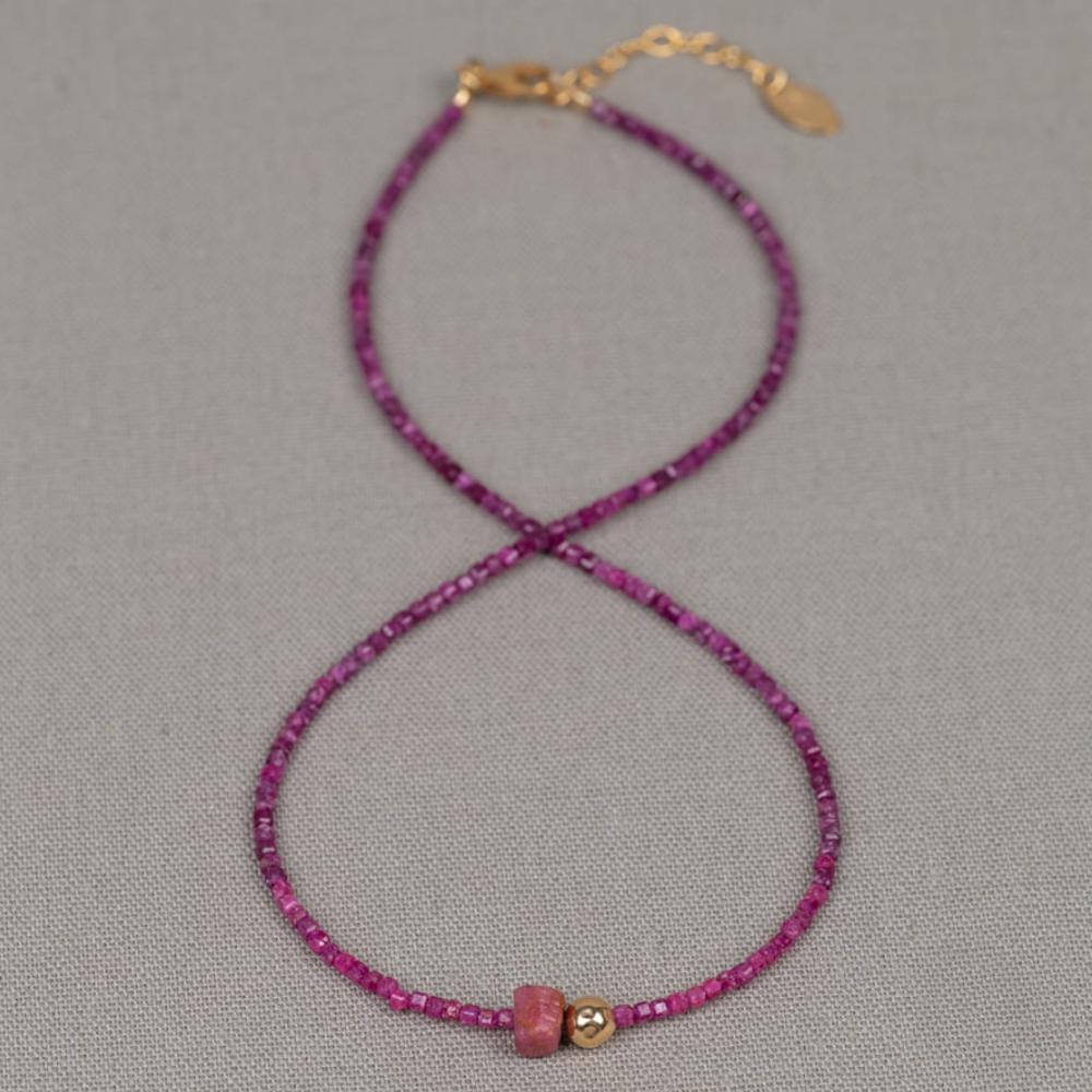 Collier gemaakt van Robijn. In het midden zit een stukje Raw Robijn, een mooi, onbewerkt stukje edelsteen met daarnaast een bolletje Goldfilled.