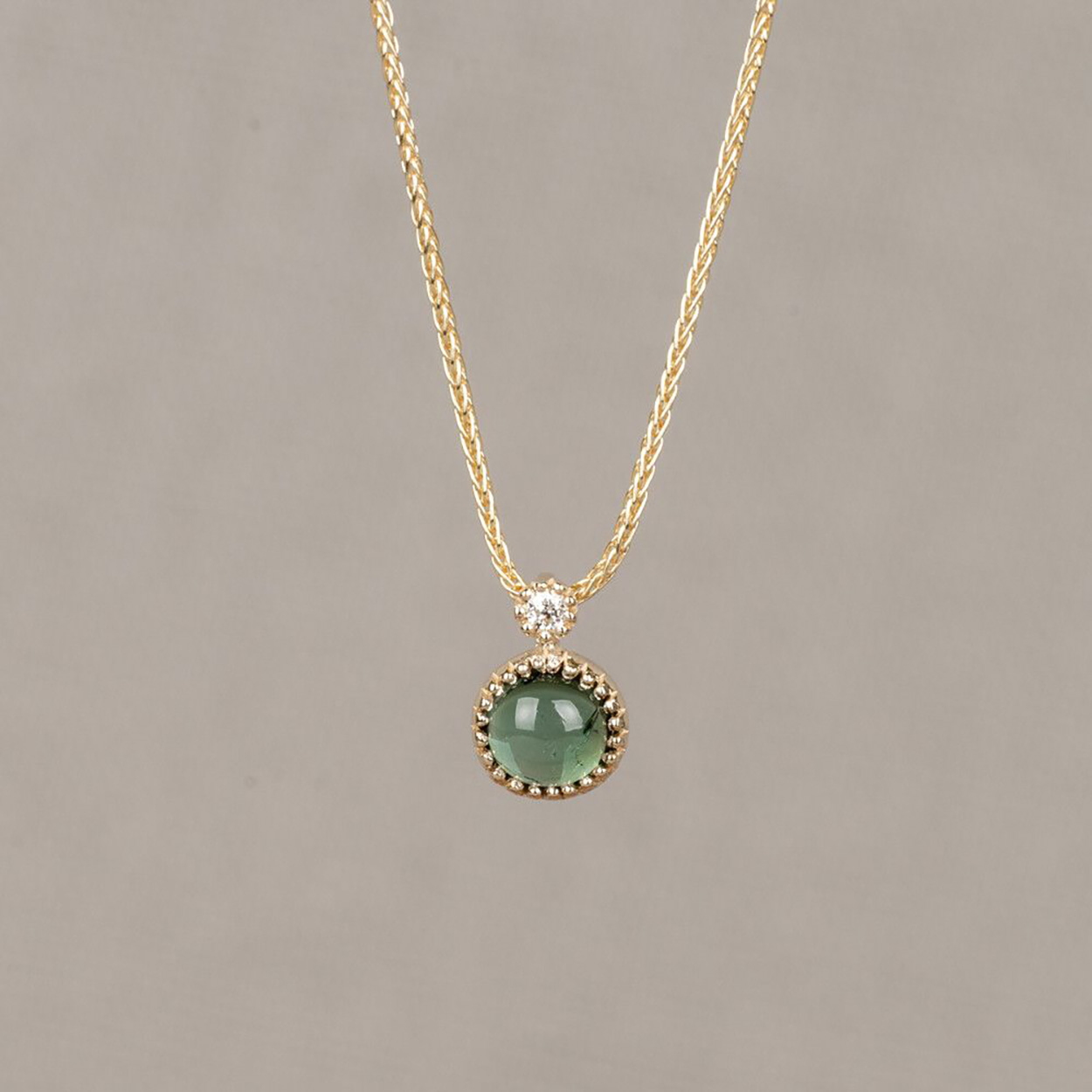 14 kt gouden schakel collier met daaraan een hanger met een toermalijn en een diamant 0.02crt. Het collier heeft een lengte van 45-45cm