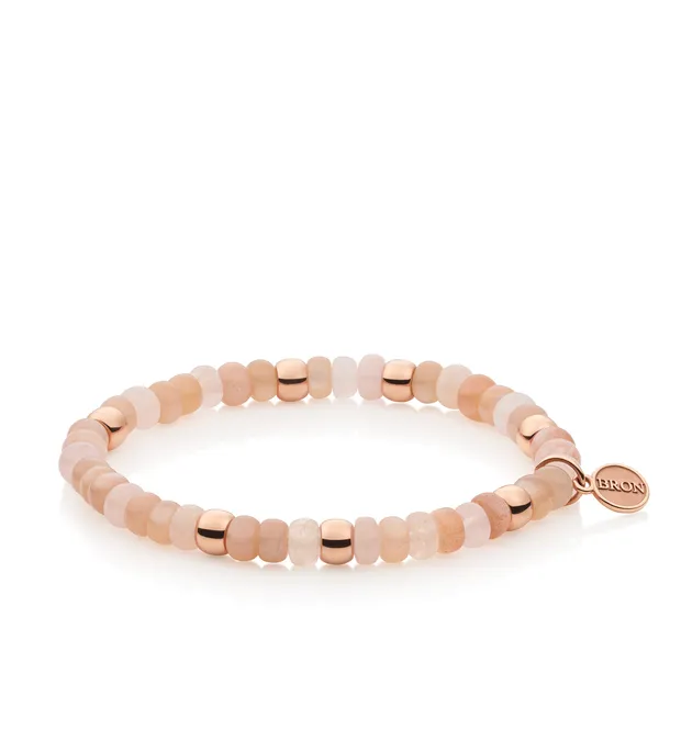 Deze elegante armband van Bron is gemaakt van 18-karaats roségoud en versierd met maansteen, roze beryl en verfijnde gouden details. Een stijlvol sieraad met het kenmerkende Bron-label, perfect voor elke gelegenheid. Het referentienummer is 8AR3985MIX01. 