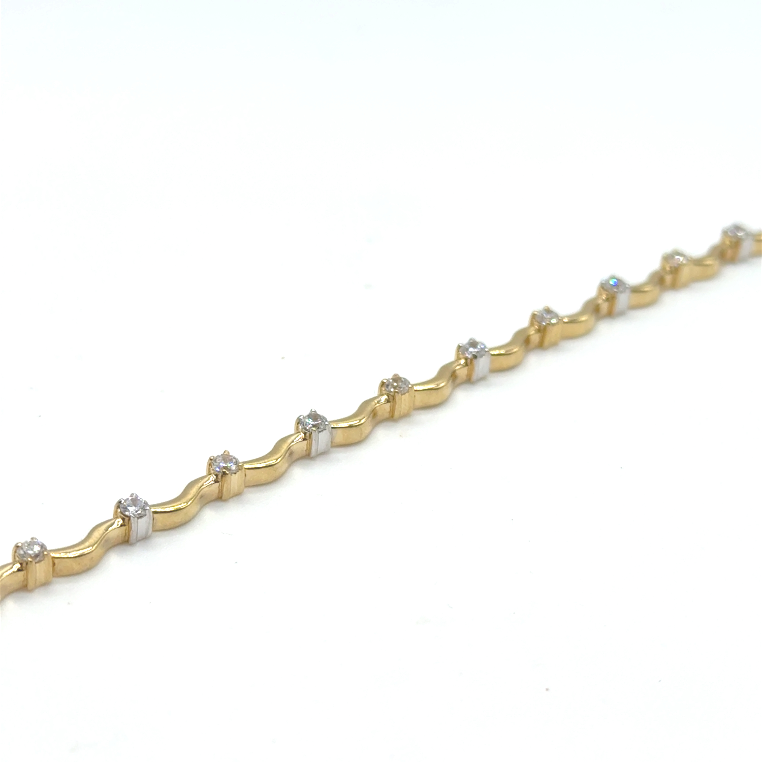 Deze geelgouden damesarmband is 2 mm breed en bevat fonkelende zirkonia-stenen. De armband is gemaakt van 14-karaats goud, weegt 9,3 gram, heeft een glanzende afwerking en is 19,5 cm lang. Draag deze elegante armband solo of gecombineerd met andere gouden sieraden voor een verfijnde look. Perfect voor elke gelegenheid!