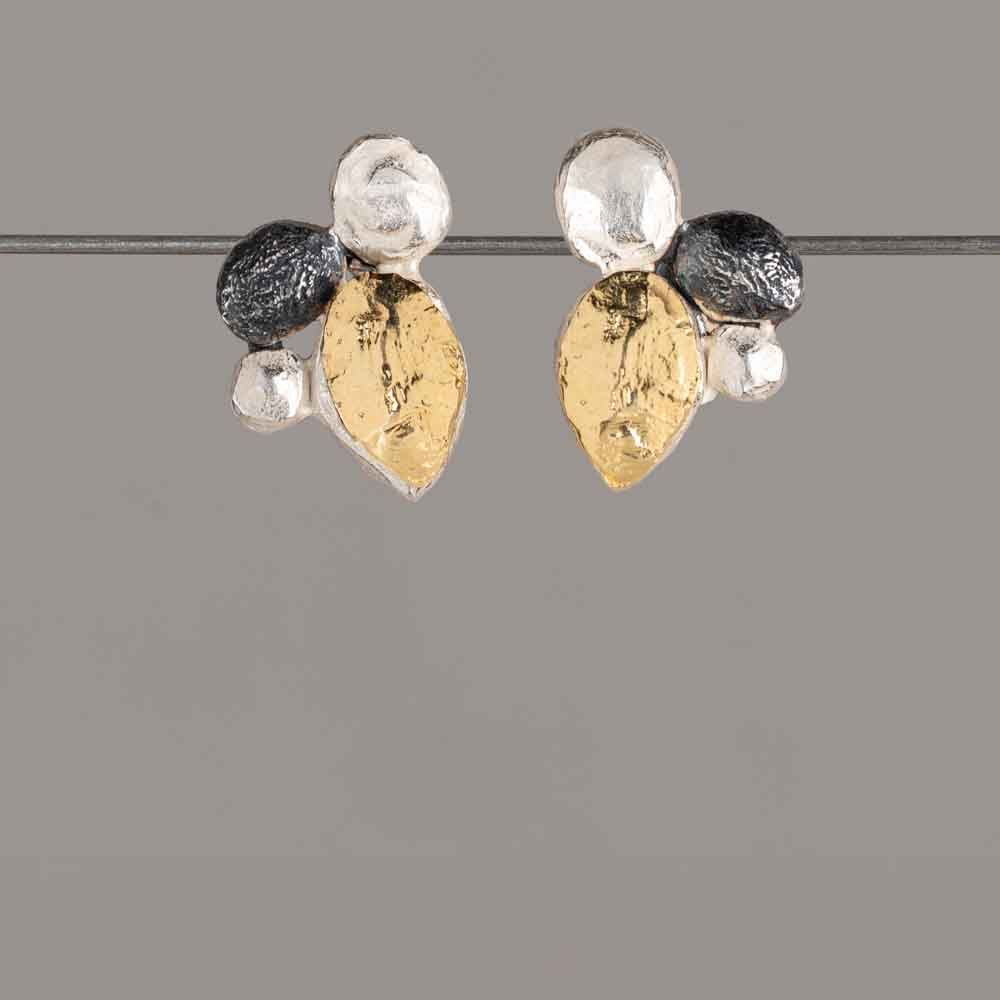 Oorknopjes van 925 sterling zilver, geoxideerd en verguld. Deze elegante oorknopjes zijn gemaakt van 925 sterling zilver en combineren een stijlvolle mix van geoxideerd en verguld zilver. De organische vormgeving is speels en verfijnd, met een subtiele knipoog naar een lieveheersbeestje
