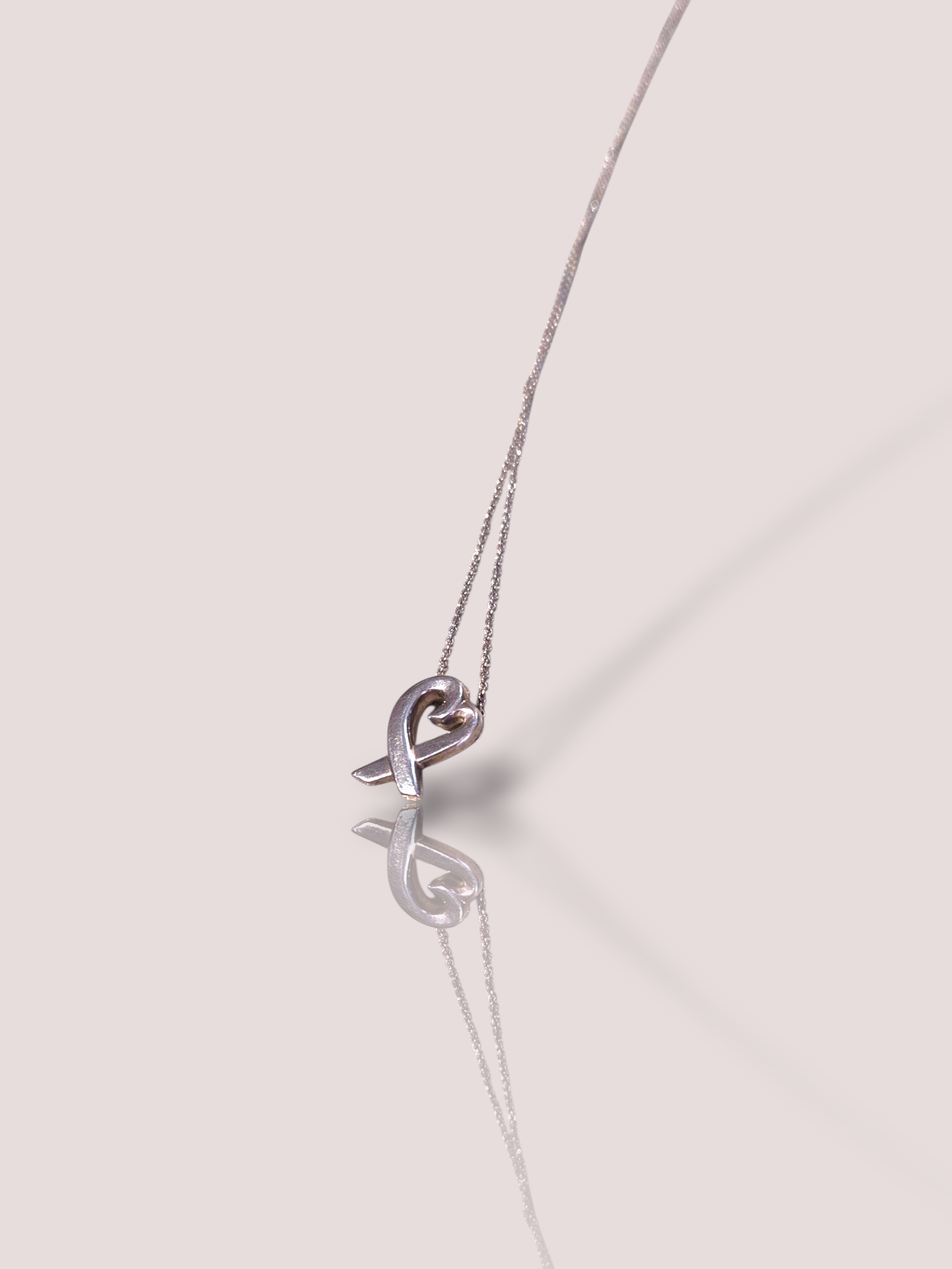 Deze Vintage zilveren Tiffany & Co Paloma hart ketting is een prachtige handgemaakt sieraad ontworpen door Paloma Picasso. Als een iconisch sieraad, benadrukt het elke outfit met tijdloze elegantie. Combineer het met een V-hals om zijn schoonheid te accentueren. Perfect voor speciale gelegenheden of dagelijks gebruik.

De hanger zit vast aan het collier zodat het prachtig om de hals blijft liggen.