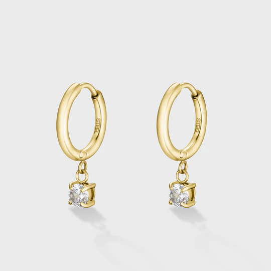 Voeg een beetje sprankeling toe aan je look met de goudkleurige Élevé Zirconia Drop oorbellen. Deze goudkleurige hoop oorbellen van 14 mm zijn versierd met een zirkonia-hanger voor een subtiele glans. De totale afmeting van de oorbel is 20,5 mm.