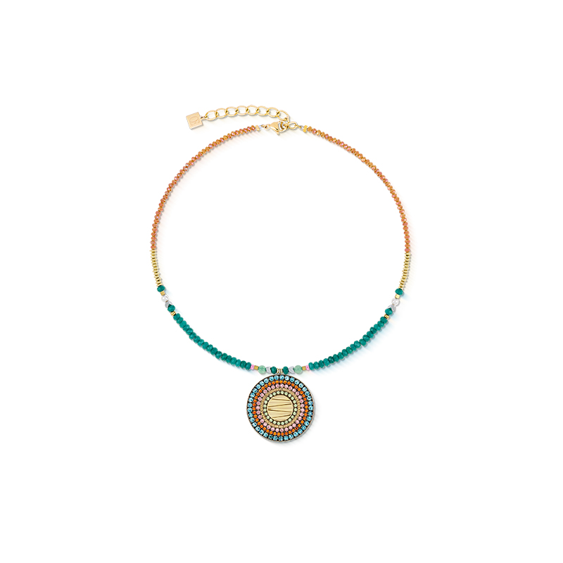 Deze expressieve ketting combineert kleurrijke lichtheid met modern design. Het centrale amulet van verguld roestvrij staal is omlijst met fijn geslepen Swarovski®-kristallen - een getextureerde blikvanger met diepte. De ketting zelf wordt gekenmerkt door de combinatie van natuurlijke materialen zoals groene aventurijn, gekleurde jade en glinsterende Crystal Pearls van Swarovski®. Een krachtig statement voor iedereen die op zoek is naar kleur en helderheid tegelijk. 