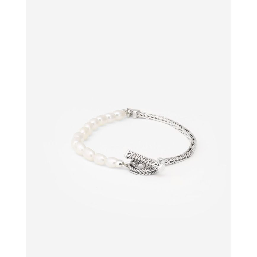 De Barbara Parel armband biedt een unieke mix van witte gekweekte ovale zoetwaterparels, gecombineerd met de kenmerkende Barbara schakel en afgewerkt met een getextureerde toggle sluiting. Dit tijdloze design is geschikt voor iedereen en kan moeiteloos worden gecombineerd met andere items uit de Buddha to Buddha collectie. Met wie verbind jij je door het dragen van deze armband? Laat jouw persoonlijke verhaal zich vervlechten met dit unieke sieraad.
