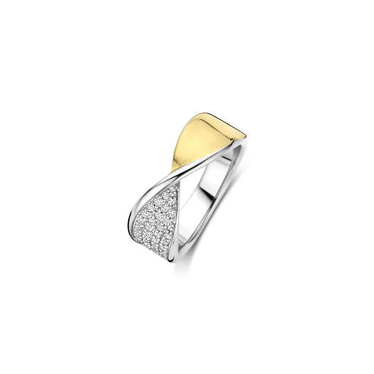 Maak een strak statement met deze TI SENTO goudkleurig vergulde zilveren ring 12393ZY. Vervaardigd uit 925 sterling zilver, wikkelt dit sculpturale design zich in een gedurfde twist om de vinger: de ene helft goudkleurig verguld, de andere helft platinakleurig verguld en pavé-gezet met briljant geslepen witte cubic zirconia. De diagonale lijn tussen glans en schittering creëert een dynamisch samenspel van contrast en beweging, perfect voor wie houdt van verfijnde impact. Draag hem solo als eyecatcher, of combineer hem met minimalistische ringen voor een moderne gelaagde look. Nikkelvrij en hypoallergeen, deze ring biedt blijvend comfort en een elegante afwerking bij elke gelegenheid.