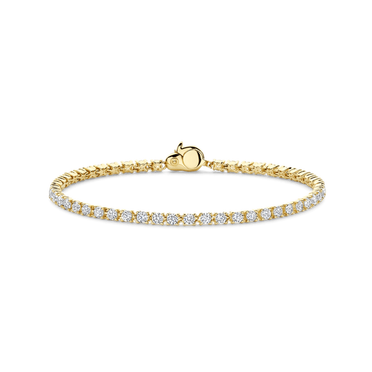 Geniet van verfijnde schittering met deze vergulde zilveren TI SENTO armband 2951ZY. Deze tennisarmband is gemaakt van 925 sterling zilver en verguld met stralend geelgoud. Hij is voorzien van een doorlopende rij met de hand gezette witte zirkonia's in ronde zettingen, die elk het licht vangen met uitzonderlijke helderheid en vuur. De warme gouden tinten contrasteren prachtig met de ijzige schittering van de stenen en bieden een verfijnde interpretatie van een klassiek silhouet. De slanke sluiting sluit naadloos aan op het ontwerp en garandeert veiligheid zonder de vloeiende lijn van glans te verstoren. Of u hem nu alleen draagt ​​als een elegant pronkstuk of gelaagd voor moderne glamour, deze armband tilt elk moment naar een hoger niveau, van alledaagse elegantie tot feestelijke gelegenheden. Een tijdloze essential in elke fijne sieradencollectie. Nikkelvrij en hypoallergeen voor comfort de hele dag.