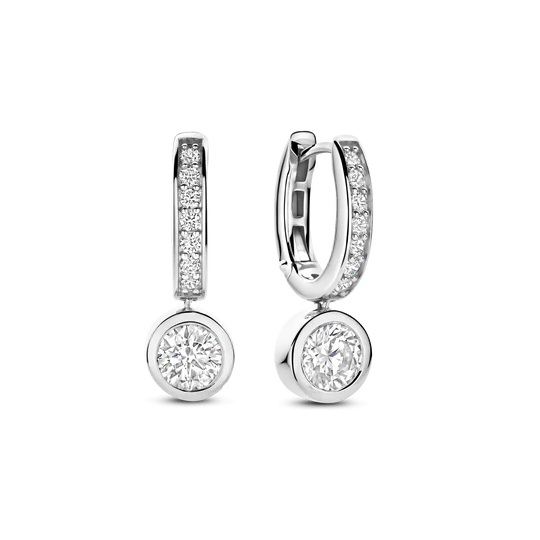 Ontdek stralende elegantie met deze TI SENTO platinakleurig vergulde oorbellen 78032ZI. Vervaardigd uit 925 sterling zilver en afgewerkt met een hoogglanzende platinakleurige laag, is iedere oorbel voorzien van een fijne rij pavé gezette witte zirconia langs de langgerekte druppel. Daaronder beweegt een briljant geslepen solitaire in een gladde randzetting zachtjes mee bij iedere beweging, en vangt hij het licht vanuit alle hoeken. Het slanke, langgerekte silhouet voegt een verfijnde fonkeling toe aan zowel dagelijkse outfits als avondlooks. Ontworpen voor de gevoelige huid, garandeert de nikkelvrije, hypoallergene constructie blijvend comfort bij elke draagbeurt.
