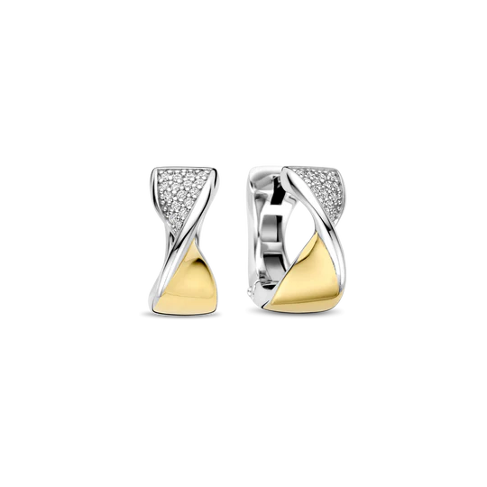 Maak indruk met deze TI SENTO goudkleurig vergulde zilveren oorbellen 78036ZY. Ontworpen met een sculpturaal profiel van 15 mm, zijn deze elegante hoops vervaardigd uit 925 sterling zilver en voorzien van een opvallend diagonaal ontwerp: de ene zijde pavé-gezet met briljant geslepen witte cubic zirconia, de andere zijde goudkleurig verguld. De platinakleurig vergulde bogen omlijsten de compositie met koele glans, wat een dynamische spanning creëert tussen zachte sprankeling en strakke glans. Of ze nu worden gedragen bij een getailleerde blazer of een off-shoulder jurk, ze voegen een verfijnde edge toe aan elke look. Nikkelvrij en hypoallergeen, deze oorbellen bieden opvallende stijl met blijvend, de hele dag durend comfort.