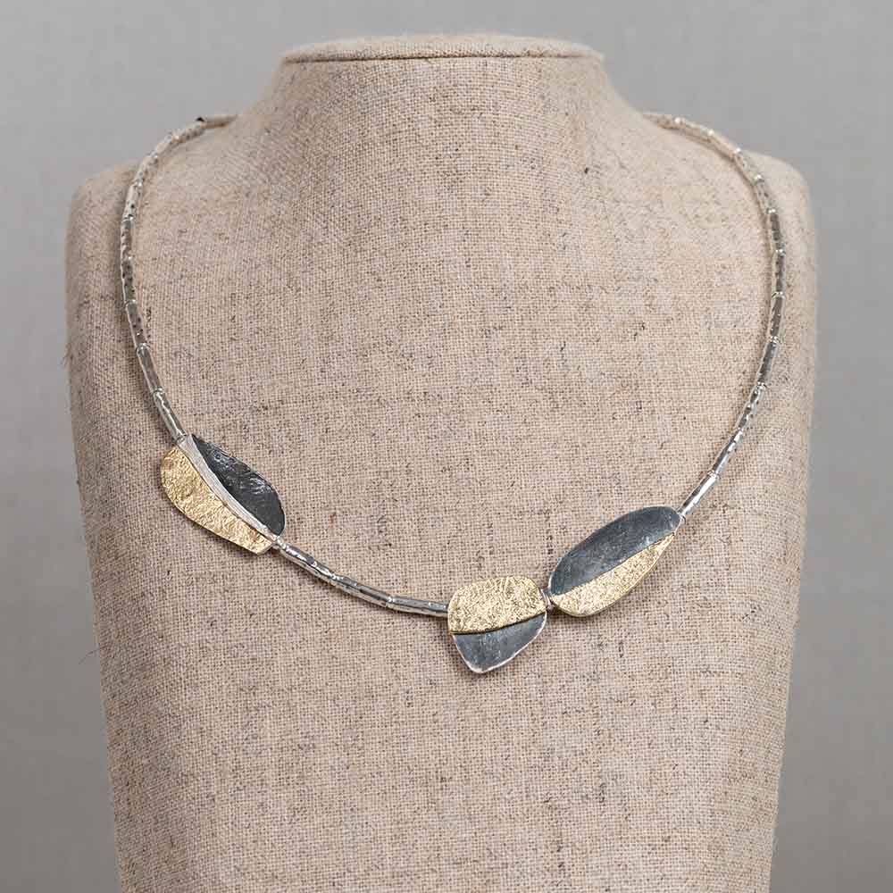 Collier gemaakt van 925 sterling zilveren buisjes en organische vlakken gemaakt van geoxideerd zilver en verguld. Combineer met de bijpassende oorbellen voor een complete look!