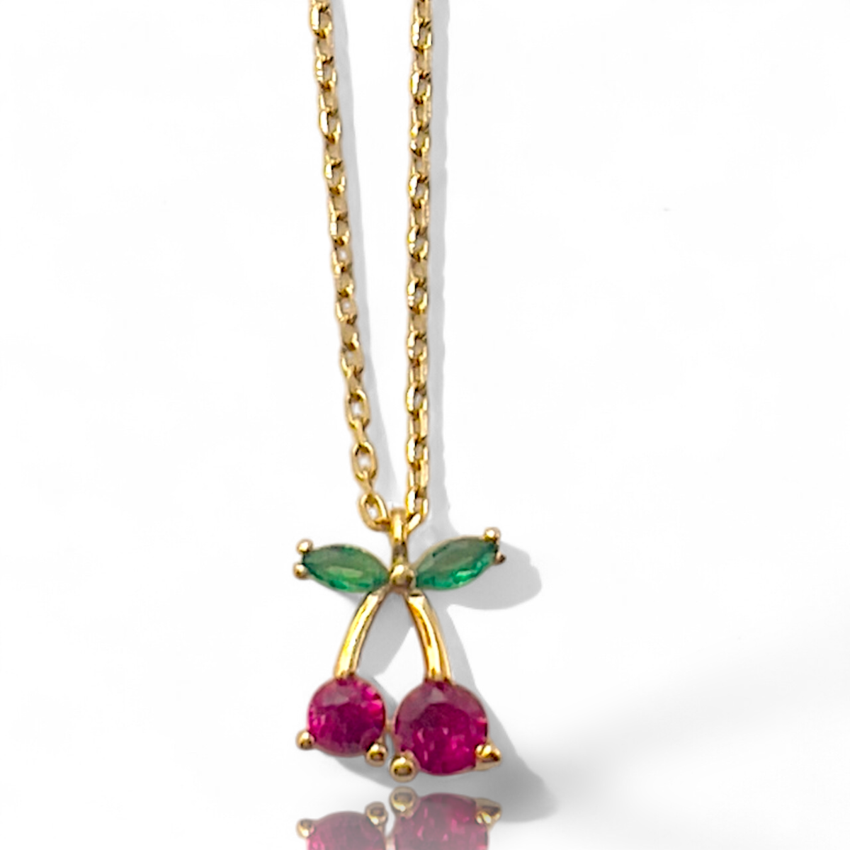 Dit 14k gouden collier, beschikt over een speels tussenstuk in de vorm van kers. Met een lengte van 45 cm is het perfect als statementstuk voor elke gelegenheid. Elegant en verfijnd, draag het subtiele sieraad bij een blouse of een avondjurk om jouw look een gouden glans toe te voegen.