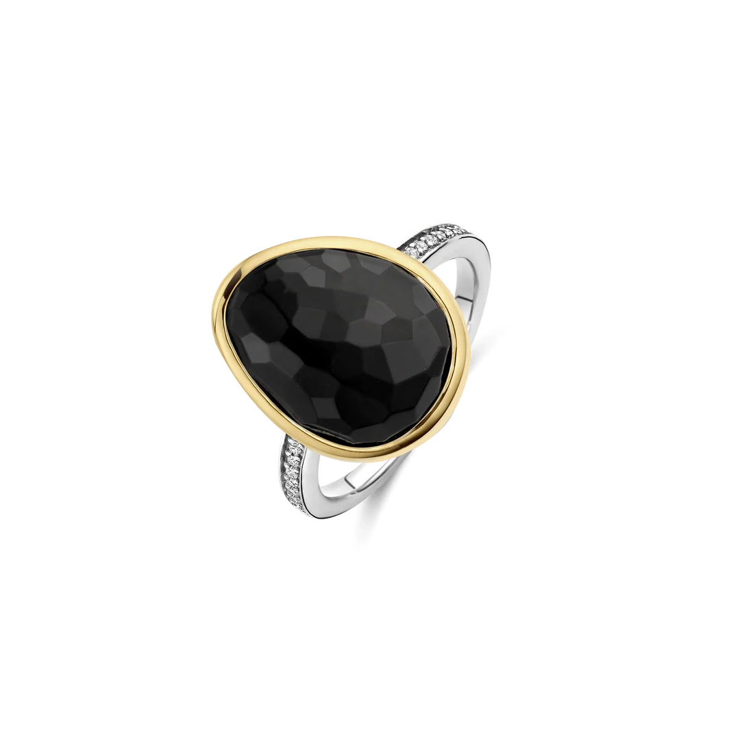 Ontdek middernachtelijke allure met deze TI SENTO goudkleurig vergulde zilveren ring 12386BY. Gevormd uit 925 sterling zilver en afgewerkt met een spiegelend platinakleurig laagje, leidt de slanke band het oog naar een organisch gevormde, diepzwarte steen waarvan het gefacetteerde “pebble”-oppervlak subtiel licht weerkaatst. Een gladde goudkleurig vergulde rand omlijst de edelsteen, terwijl een taps toelopende rij van pavé-gezette witte cubic zirconia langs één zijde een verfijnde sprankeling toevoegt zonder het geheel te overheersen. Draag de ring solo voor krachtig contrast, of stapel hem met slanke metallic ringen om een zorgvuldig samengestelde glans te creëren. Nikkelvrij en hypoallergeen, dit sieraad blijft de hele dag huidvriendelijk.