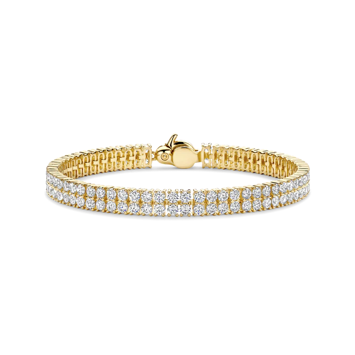 Laat je omringen door stralende verfijning met deze TI SENTO vergulde tennisarmband 23067ZY, een geraffineerd icoon, heruitgevonden in warme gouden tonen. Met de hand vervaardigd uit hoogwaardig 925 sterling zilver en rijkelijk afgewerkt met een goudkleurige vergulding schittert deze armband met een dubbele rij briljant geslepen witte zirconia, waarbij elke steen zorgvuldig is gezet om een eindeloze stroom van fonkeling te creëren. Het verfijnde, door pavé geïnspireerde ontwerp brengt vintage glamour naar het heden en straalt elegantie uit vanuit iedere hoek. De warme vergulding voegt een rijke, tijdloze gloed toe, waardoor dit het perfecte sieraad is voor zowel formele gelegenheden als dagelijkse luxe. Of hij nu alleen wordt gedragen om zijn schittering te benadrukken of gecombineerd met andere TI SENTO armbanden, hij verheft elke look moeiteloos.