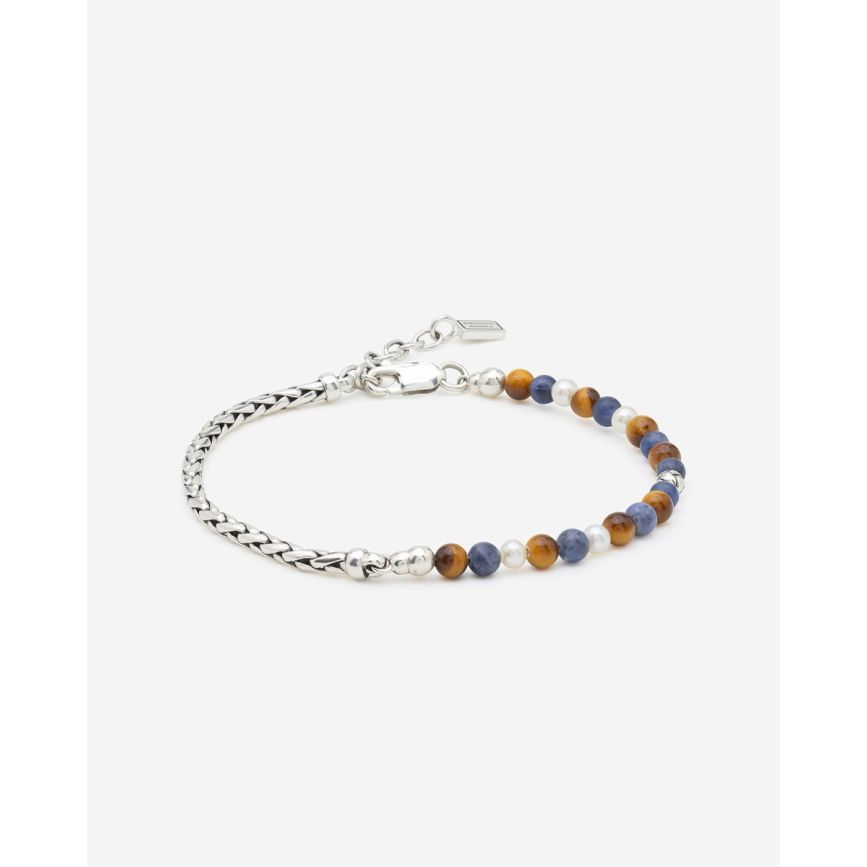 Laat je betoveren door onze nieuwe Spirit Bead Stacking Armbanden! De Spirit Bead Stacking Armband Zilver Tiger Eye Sodalite wordt gekenmerkt door 4mm Gemstone Spirit Beads en een elegante compositie van verfijnde zoetwaterparels, 925 sterling zilveren George Beads en het kenmerkende George Mini-vlechtwerk. Specifiek ontworpen met kleinere Gemstone Beads en subtiel verstelbaar dankzij de hoogwaardige karabijnsluiting, voor een perfecte, unisex pasvorm bij elke pols. De armband is ge&iuml;nspireerd door Balinese bidkralen en heeft helende werkingen. Zo bevordert Tiger Eye innerlijke kracht en zelfvertrouwen, helpt het bij het nemen van beslissingen en biedt het bescherming tegen negatieve invloeden. Sodalite staat bekend om zijn kalmerende energie, versterkt het zelfinzicht en bevordert harmonie tussen gevoel en verstand. Edelstenen zoals Tiger Eye en Sodalite zijn natuurproducten en kunnen gevoelig zijn voor harde stoten, water en chemische middelen. Vermijd contact met parfum, schoonmaakmiddelen of langdurige blootstelling aan zonlicht om de kleur en glans te behouden. Wie ga jij verrassen met deze Spirit Bead Stacking Armband?
