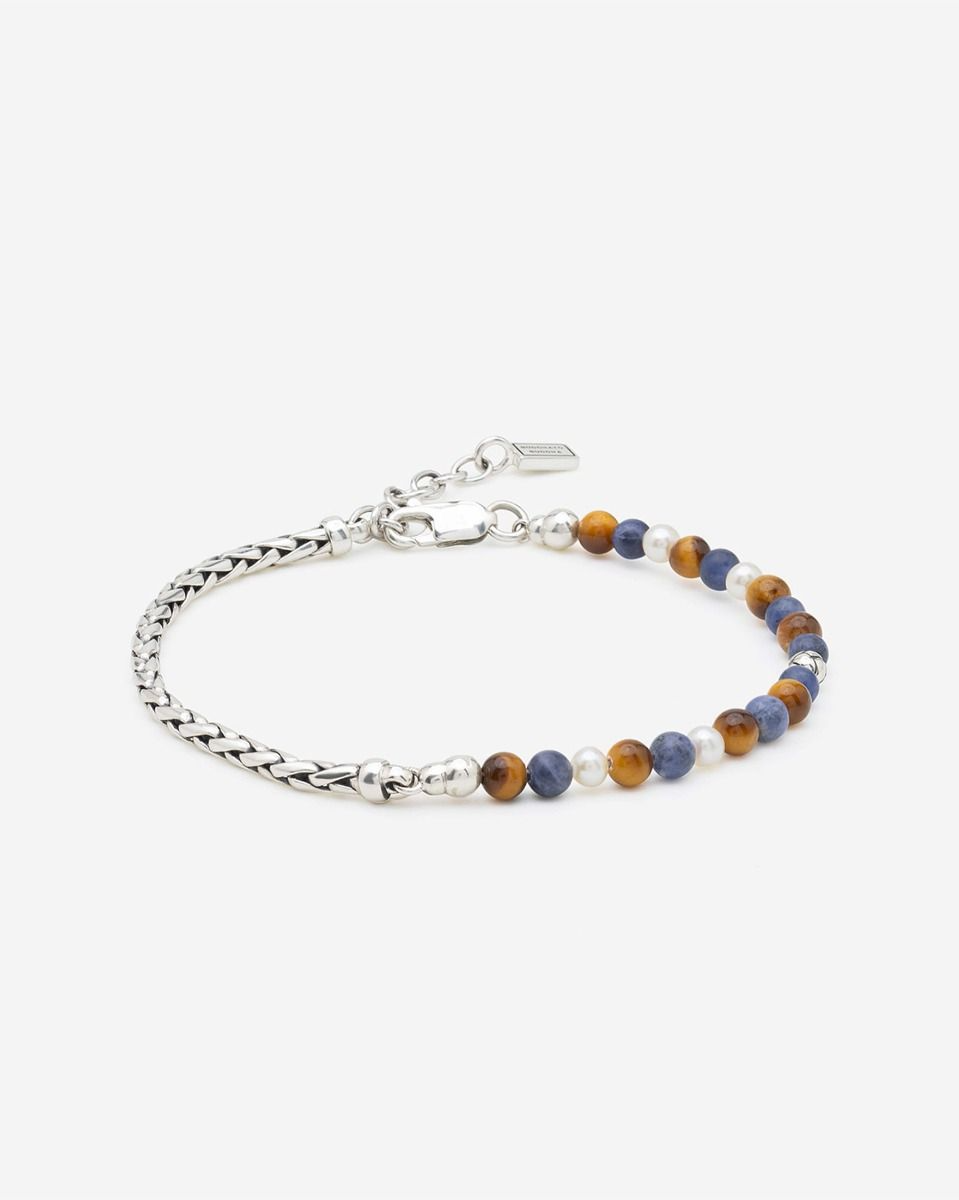 Laat je betoveren door onze nieuwe Spirit Bead Stacking Armbanden! De Spirit Bead Stacking Armband Zilver Tiger Eye Sodalite wordt gekenmerkt door 4mm Gemstone Spirit Beads en een elegante compositie van verfijnde zoetwaterparels, 925 sterling zilveren George Beads en het kenmerkende George Mini-vlechtwerk. Specifiek ontworpen met kleinere Gemstone Beads en subtiel verstelbaar dankzij de hoogwaardige karabijnsluiting, voor een perfecte, unisex pasvorm bij elke pols. De armband is ge&iuml;nspireerd door Balinese bidkralen en heeft helende werkingen. Zo bevordert Tiger Eye innerlijke kracht en zelfvertrouwen, helpt het bij het nemen van beslissingen en biedt het bescherming tegen negatieve invloeden. Sodalite staat bekend om zijn kalmerende energie, versterkt het zelfinzicht en bevordert harmonie tussen gevoel en verstand. Edelstenen zoals Tiger Eye en Sodalite zijn natuurproducten en kunnen gevoelig zijn voor harde stoten, water en chemische middelen. Vermijd contact met parfum, schoonmaakmiddelen of langdurige blootstelling aan zonlicht om de kleur en glans te behouden. Wie ga jij verrassen met deze Spirit Bead Stacking Armband?
 