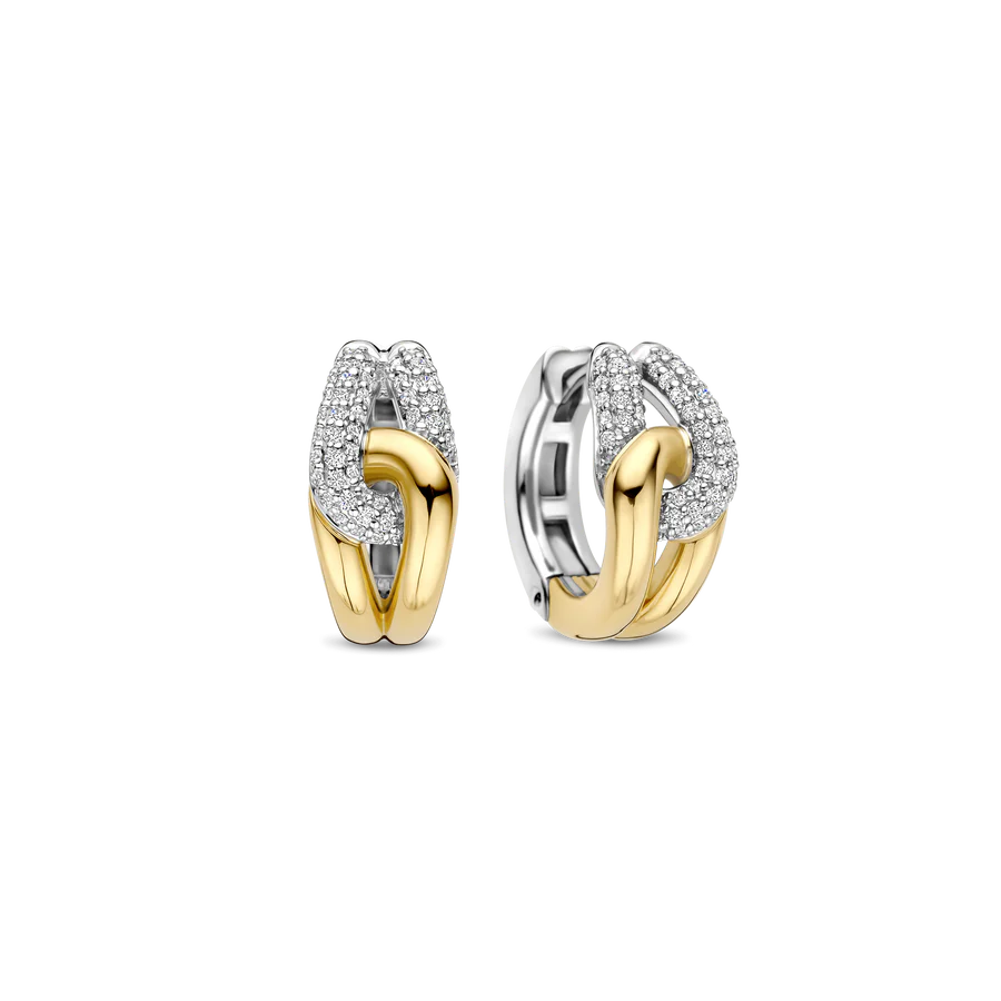 Stap in de spotlight met deze sculpturale TI SENTO vergulde oorbellen 78033ZY. Vervaardigd uit 925 sterling zilver, wikkelen ze zich om het oor in een gedurfde draai van contrast en schittering. De ene zijde is goudkleurig verguld, terwijl de andere zijde platinakleurig verguld is en bezet met twee gebogen rijen briljant geslepen witte zirconia. Het verstrengelde ontwerp vangt het licht vanuit elke hoek en zorgt voor een perfecte balans tussen textuur, fonkeling en verfijning. Nikkelvrij en hypoallergeen, deze oorbellen zijn gemaakt voor luxe die de hele dag door gedragen kan worden, met een zelfverzekerde uitstraling.

