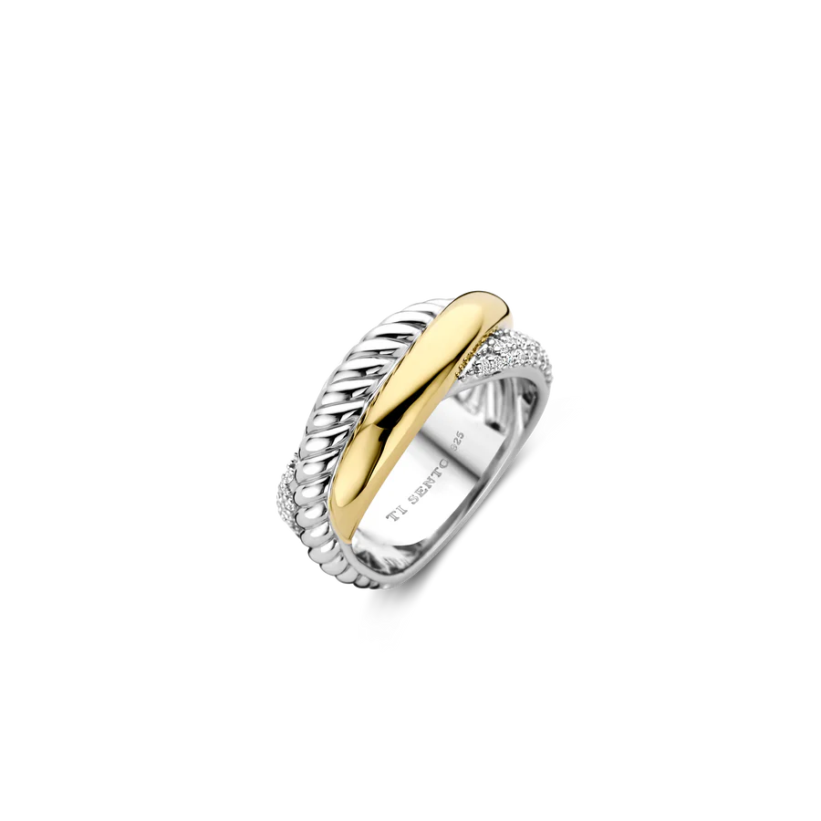 Laat je verleiden door de betoverende combinatie van texturen en metalen met deze TI SENTO vergulde zilveren ring 1973ZY. Dit gedurfde sieraad heeft drie met elkaar verweven ringen: één is verguld met glanzend geel goud, wat een warm contrast creëert met het koele zilver van de andere twee ringen. Een andere ring heeft een gedraaid ontwerp, wat een vleugje dynamiek toevoegt, en de derde ring is versierd met een fonkelende pavé van witte cubic zirconia stenen, wat een vleugje weelderige schittering aan het stuk toevoegt. Gemaakt van 925 sterling zilver en verzilverd voor blijvende schittering, is deze ring een bewijs van moderne luxe. Het complexe ontwerp en de opvallende combinatie van materialen maken het een echt statement stuk. Voeg wat flair toe aan je dagelijkse look met dit gedurfde accessoire. Vakkundig vervaardigd voor gevoelige huiden, zorgt deze nikkelvrije en hypoallergene ring voor blijvend comfort en kwaliteit.

