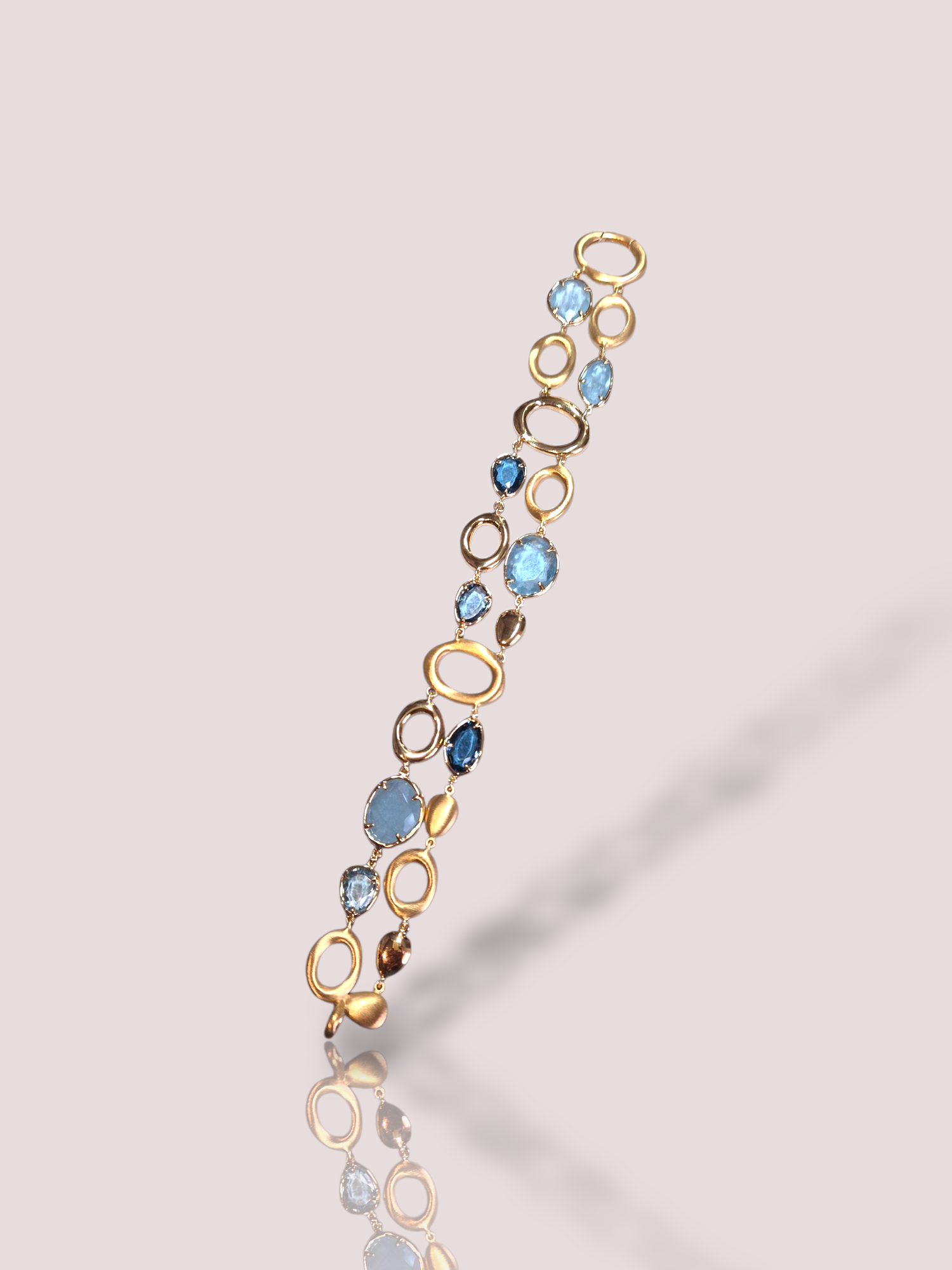 Deze Peroni & Pari 18k geel gouden armband heeft schitterende details met zowel topaas als aquamarijn. Deze armband, gecategoriseerd als sieraad en specifiek als armband, straalt luxe uit. Draag hem solo voor een elegante uitstraling of combineer met andere fijne armbanden voor een modieuze, gelaagde look. Perfect voor elke gelegenheid!

De armband heeft deels gematteerd bewerkt goud en deels glanzend goud. De armband bevat heldere blauwe aquamarijn en prachtige Londen Blue topaas en Swiss Blue topaas.