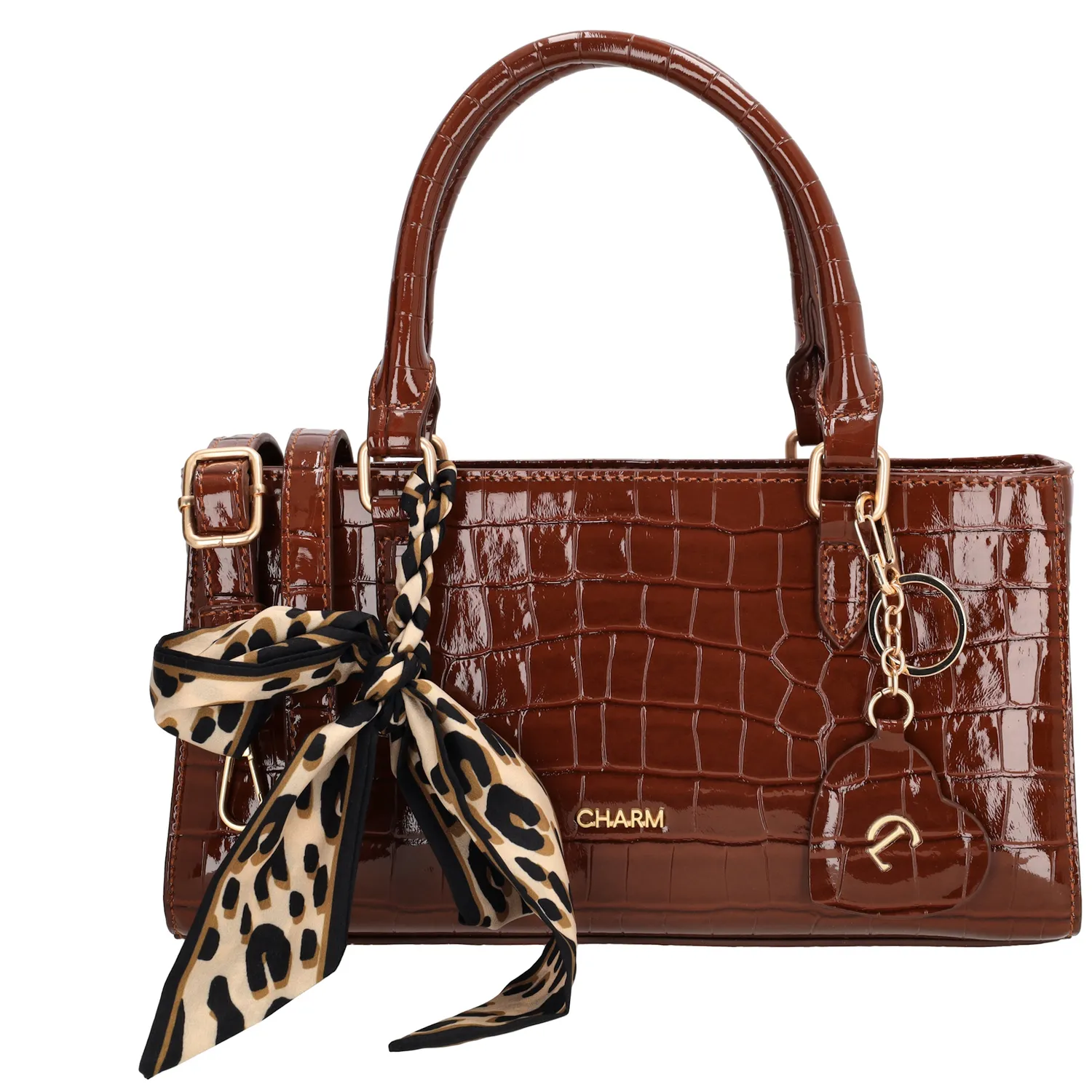 De Charm London Knightsbridge Handtas is een elegante tas met een stijlvolle croco laklook. Dankzij de dubbele handvatten draag je deze tas comfortabel in de hand of over de arm – perfect voor een dagje uit of een chique gelegenheid.

De tas sluit veilig met een ritssluiting en biedt binnenin een praktisch ritsvak en een telefoonvak, zodat je je essentials netjes kunt organiseren. De glanzende goudkleurige details geven de tas een luxueuze uitstraling.

Als speels detail is de tas afgewerkt met een hartvormige sleutelhanger met spiegeltje en een decoratief sjaaltje dat op meerdere manieren te dragen is.

Kenmerken:


Croco laklook

Ritssluiting

Ritsvak en telefoonvak aan de binnenkant

Dubbele handvatten

Verstelbare en afneembare schouderband

Hartvormige sleutelhanger met spiegel

Inclusief decoratief sjaaltje