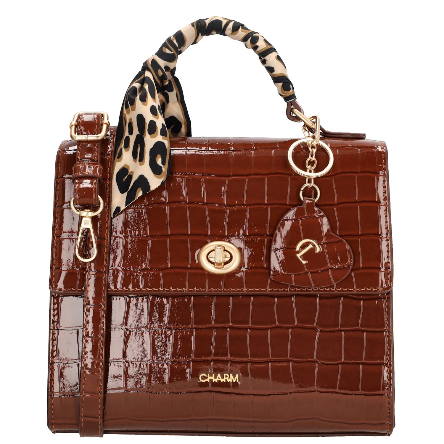 De Charm London Knightsbridge Handtas is een stijlvolle handtas met een glanzende croco laklook en verfijnde details. Dankzij het compacte ontwerp en de elegante afwerking is deze tas perfect voor een dagje uit of een diner in stijl.

De tas sluit met een ritssluiting en een overslag met kliksluiting, zodat je spullen veilig opgeborgen zijn. Aan de binnenkant vind je een ritsvak en een telefoonvak om alles overzichtelijk mee te nemen. Het handvat ligt prettig in de hand en geeft de tas een klassieke uitstraling.

Als speelse touch is de tas afgewerkt met een hartvormige sleutelhanger met spiegeltje en een decoratief sjaaltje dat je op meerdere manieren kunt dragen.

Kenmerken:

Croco laklook met overslag en kliksluiting

Ritssluiting voor extra veiligheid

Ritsvak en telefoonvak aan de binnenkant

Stevig handvat

Hartvormige sleutelhanger met spiegel

Inclusief sjaaltje, op verschillende manieren te dragen