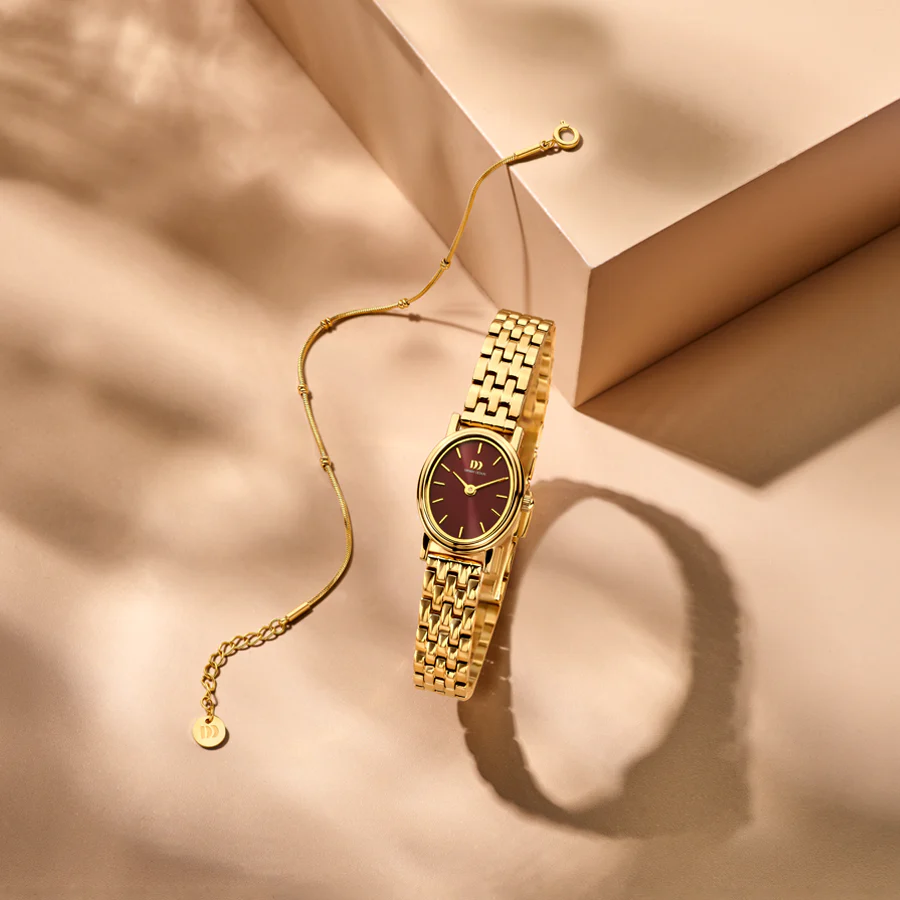 Stap in in de wereld van tijdloze elegantie met de Eloise Special Edition, een verfijnd horloge geïnspireerd op de gracieuze vorm van een antieke handspiegel. Deze exclusieve editie betovert met zijn diepe bordeauxrode wijzerplaat, die rijkdom en warmte oproept. De onderscheidende ovale kast, gecombineerd met een zacht gebogen bezel, doet denken aan de charme van antieke gouden fotolijstjes en koninklijke spiegels. 

