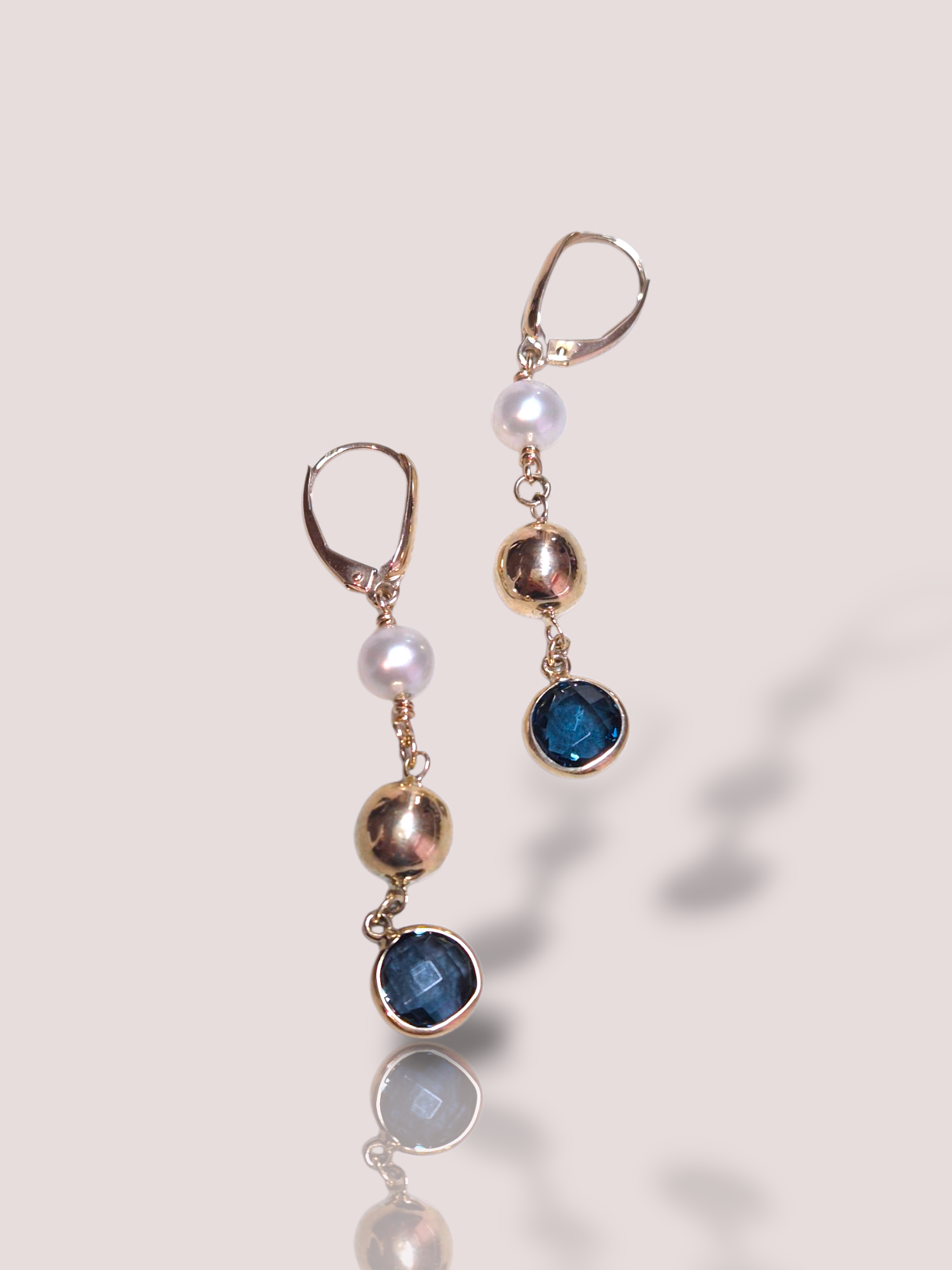 Deze prachtige oorbellen, zijn een schitterende aanvulling voor elke sieradencollectie. Ze zijn gemaakt van 14-karaats geelgoud en verfraaid met twee blauwe topazen en zoetwaterparels in een fantasievorm. Perfect voor een elegante uitstraling bij zowel alledaagse als feestelijke gelegenheden. Voeg ze toe aan je collectie voor een vleugje luxe.