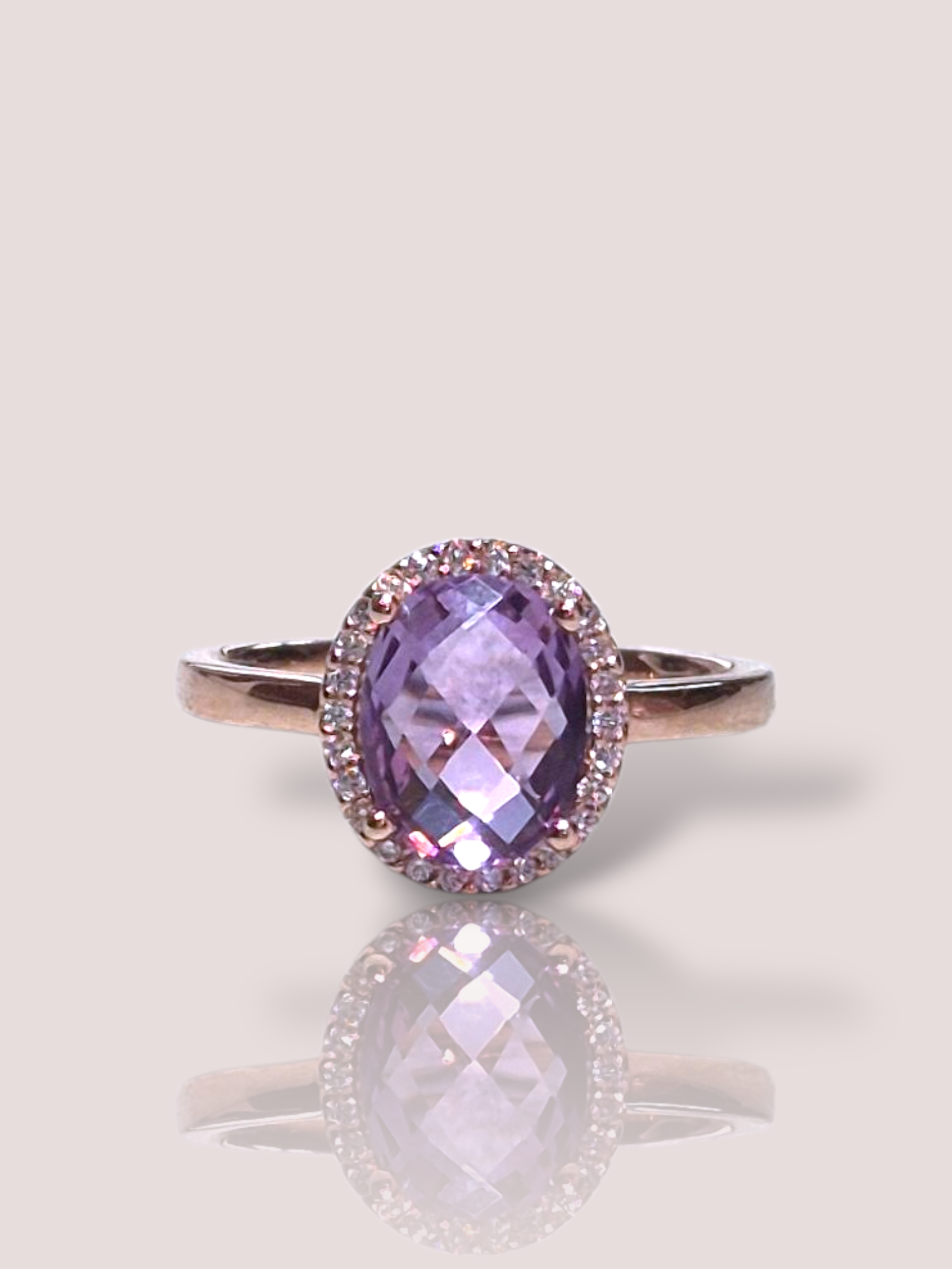 De Amethist & Diamant ring in 14k roségoud  biedt een prachtige ovaalvormige amethist in briljantslijp, met een gewicht van 0.10 karaat, omringd door SI1-diamanten in de kleur H. Perfect voor elegante evenementen, draagt u deze ring op uw rechterringvinger om zijn schittering optimaal te laten zien. Beschikbaar in maat 52.