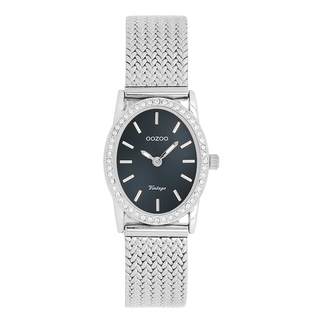 De klassieke look blijft centraal staan ​​in deze trendy serie en daarom is dit ovale OOZOO vintage design met een speelse knipoog dé must-have van het seizoen! Dit dameshorloge combineert mode en comfort met een 28x23 mm zilverkleurige metalen kast met kristallen en een donkerblauwe sunray wijzerplaat. De zilverkleurige metalen V-mesh band maakt dit horloge tot een trendy accessoire dat je elke dag kunt dragen. De wijzerplaat heeft zilverkleurige streepjescijfers en bijpassende wijzers. De C20431 geeft je outfit een sprankeling. Het mineraalglas ligt in een mm dunne metalen horlogekast met IP-coating. Dit design heeft een roestvrijstalen achterplaat en is nikkelvrij. Dit horloge heeft een 2ATM Japans uurwerk en wordt geleverd met 2 jaar garantie.