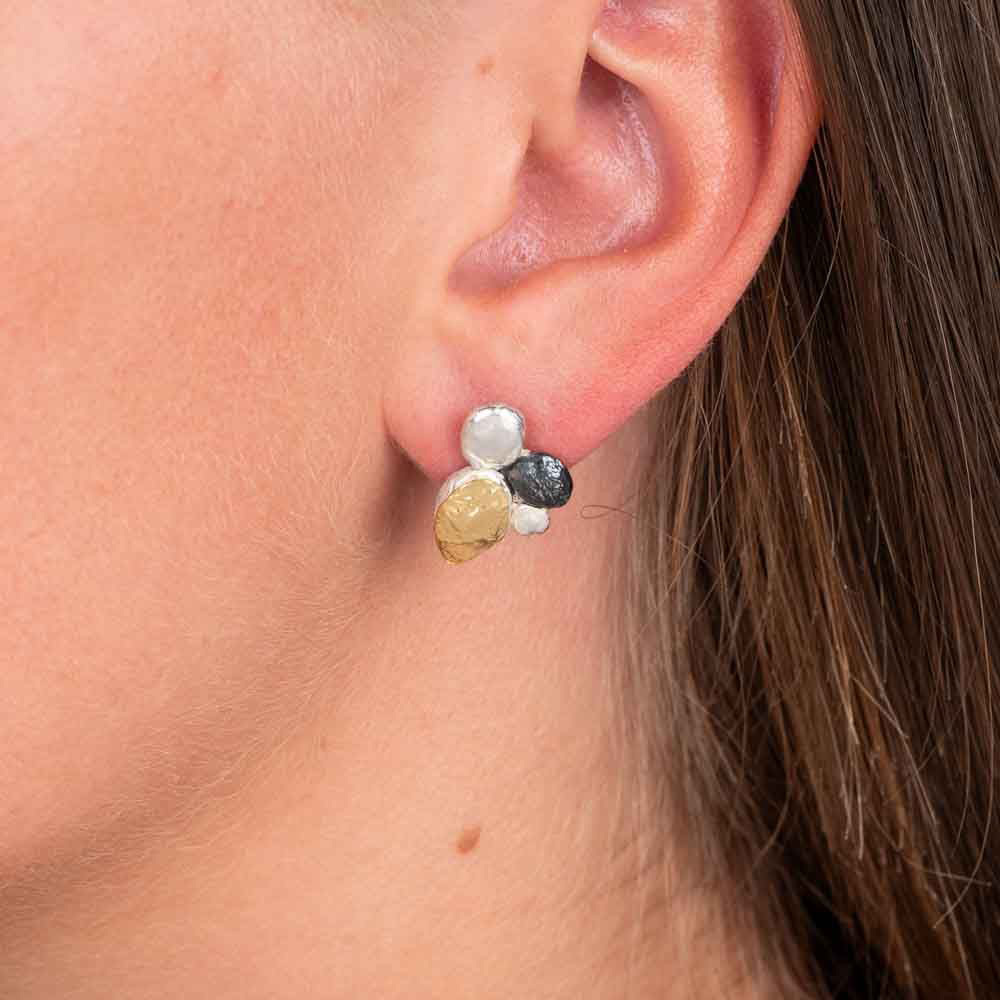 Oorknopjes van 925 sterling zilver, geoxideerd en verguld zilver. 
De organische vormgeving is speels en verfijnd, met een subtiele knipoog naar een lieveheersbeestje. Combineer met het bijpassende collier voor een complete look!