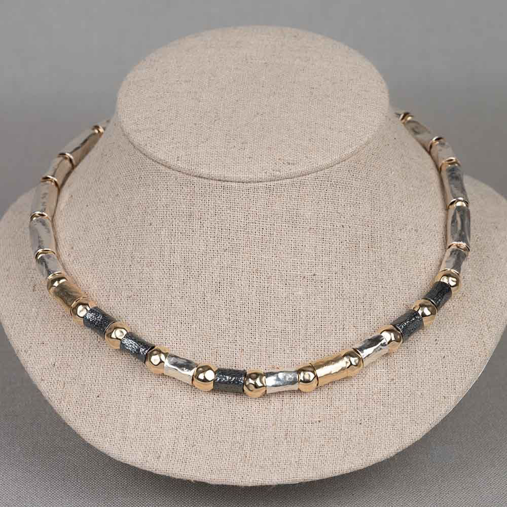 Collier van het merk Jéh Jewels. Gemaakt van 925 sterling zilver, geoxideerd zilver en goldfilled. Het collier bestaat uit verschillende grootte buisjes en hamerslag balletjes. Het collier is erg soepel waardoor hij mooi valt in de hals. 