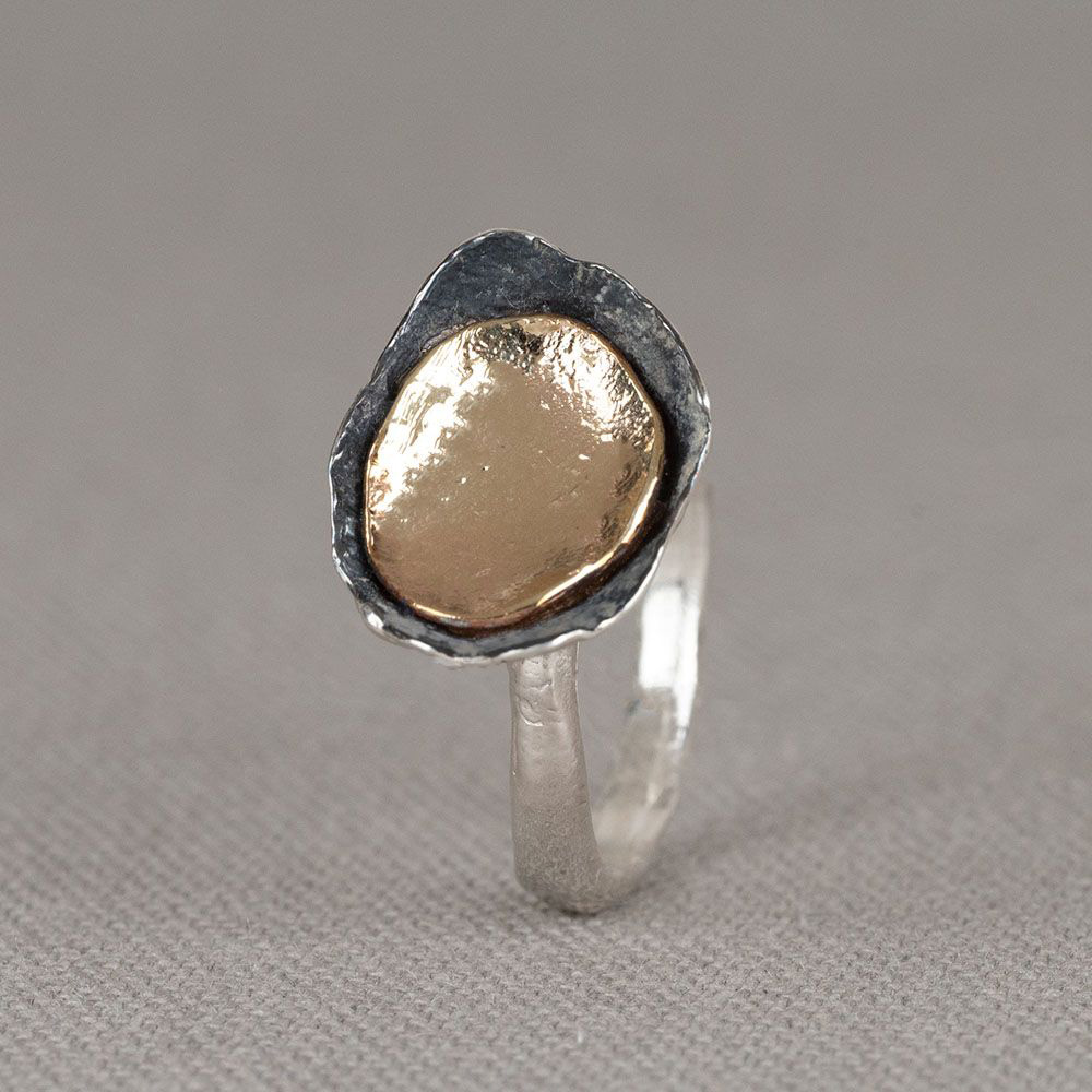 Een bijzondere ring gemaakt van 925 sterling zilver met daarop een schaaltje van geoxideerd zilver en 9 karaat. Draag deze ring in combinatie met de bijpassende oorbellen en het bijpassende collier voor een complete look!