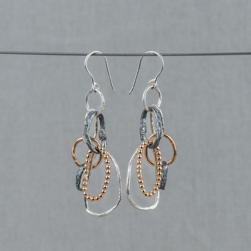 Oorhangers gemaakt van 925 sterling zilver, geoxideerd zilver en Goldfilled. Er zitten verschillende vormen ringetjes aan deze oorbellen, wat hem erg speels en uniek maakt! 